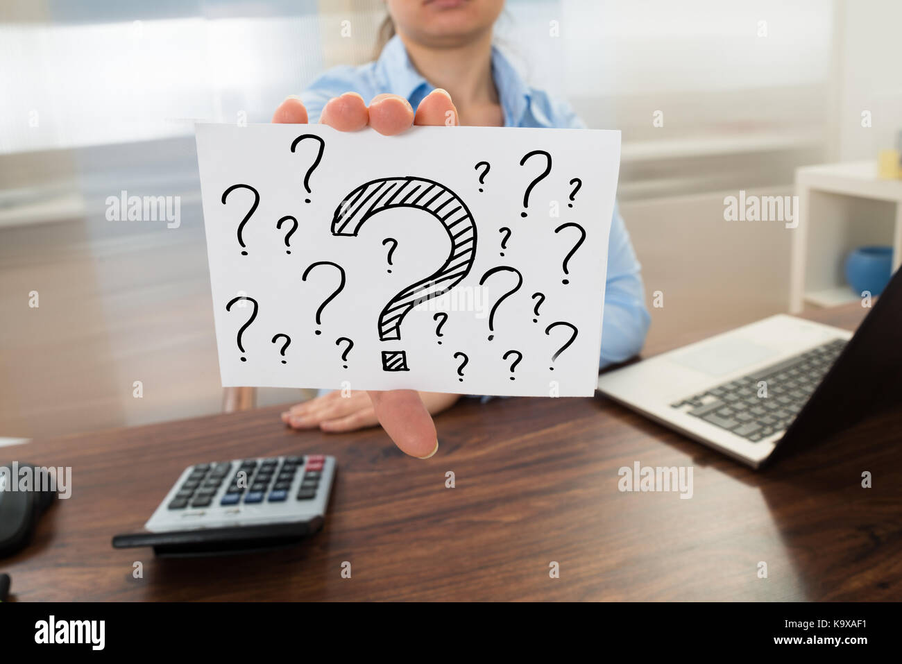Businesswoman showing question mark signe sur placard in office Banque D'Images