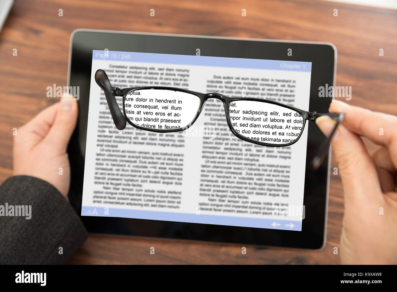 Personne de lecture d'e-livre sur la tablette numérique avec des lunettes Banque D'Images