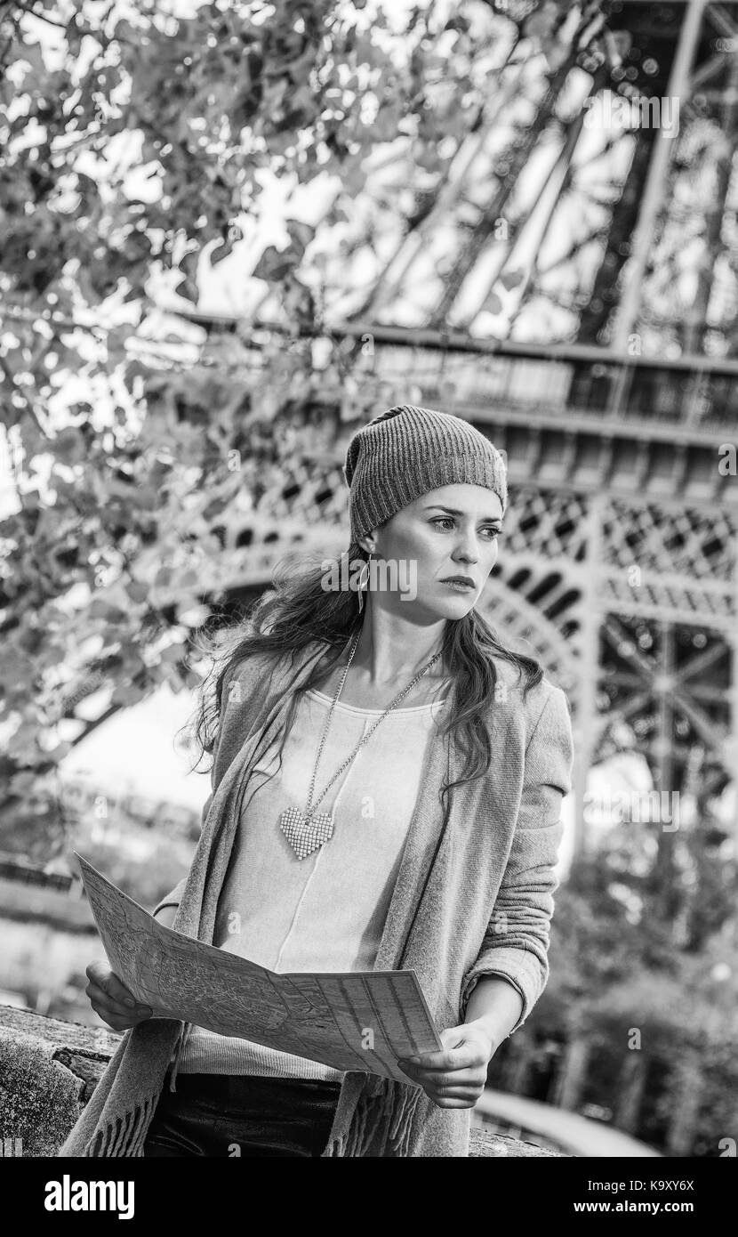 Escapades d'automne à Paris. jeune femme élégante sur le quai près de la tour Eiffel à Paris, France holding la carte et à la recherche dans la distance Banque D'Images