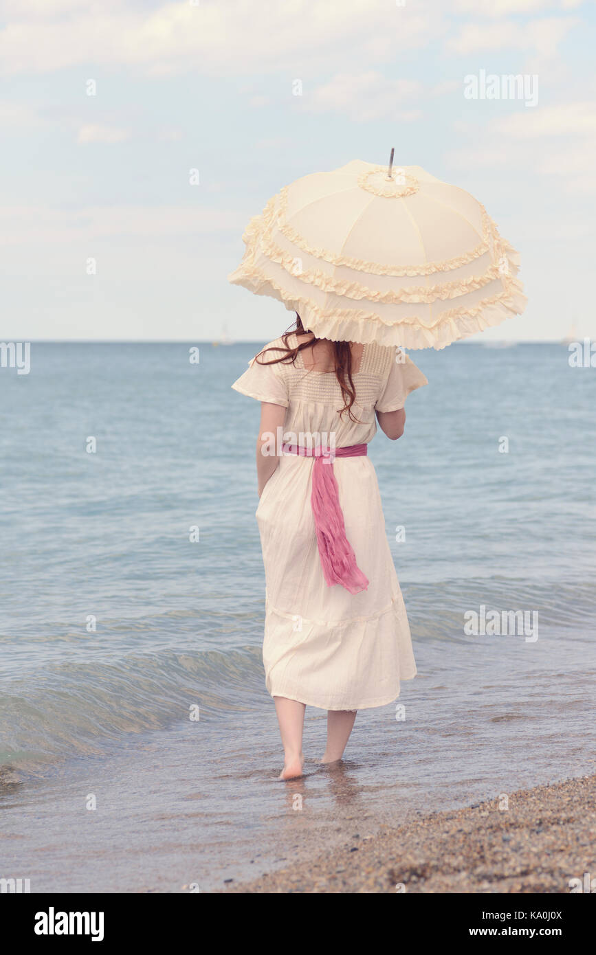 Vintage femme sur la plage avec parasol Photo Stock - Alamy