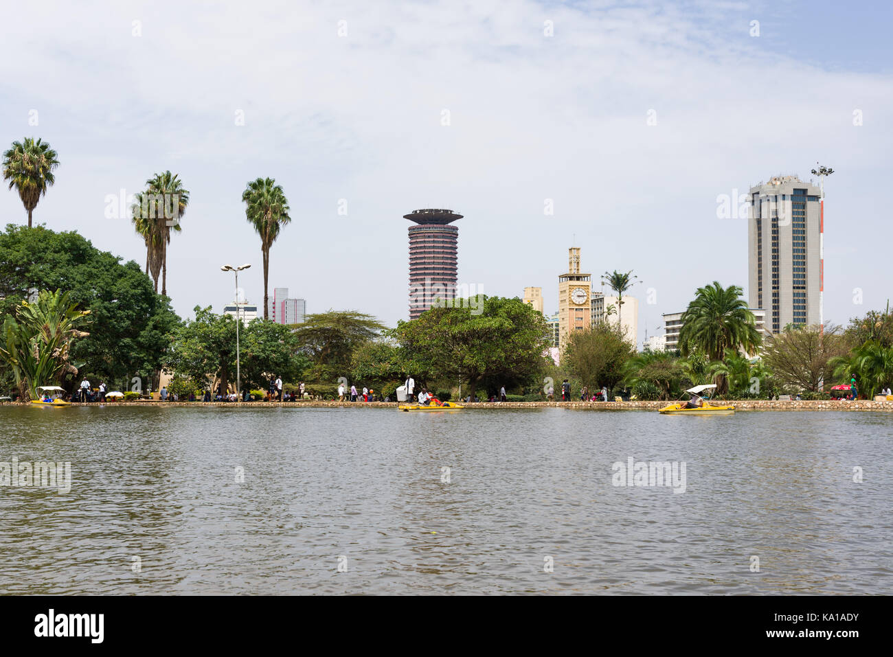 Les personnes bénéficiant de colporter des promenades en bateau sur le lac avec le Centre de conférences International Kenyatta en arrière-plan, Uhuru Park, Nairobi, Kenya, Afrique de l'Est Banque D'Images