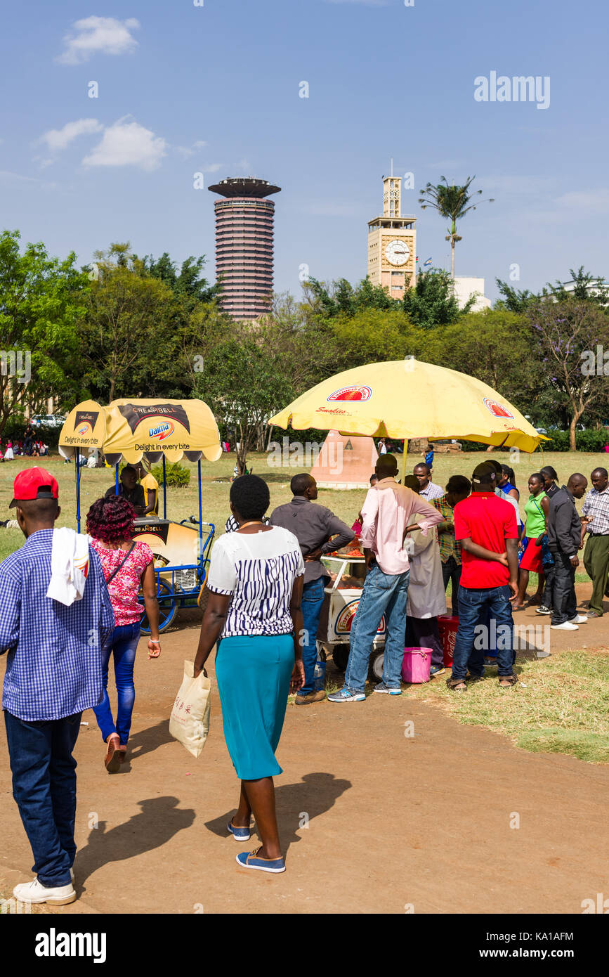 Stands de nourriture avec des parasols de collations à des gens comme ils marchent à travers Uhuru Park, Nairobi, Kenya, Afrique de l'Est Banque D'Images