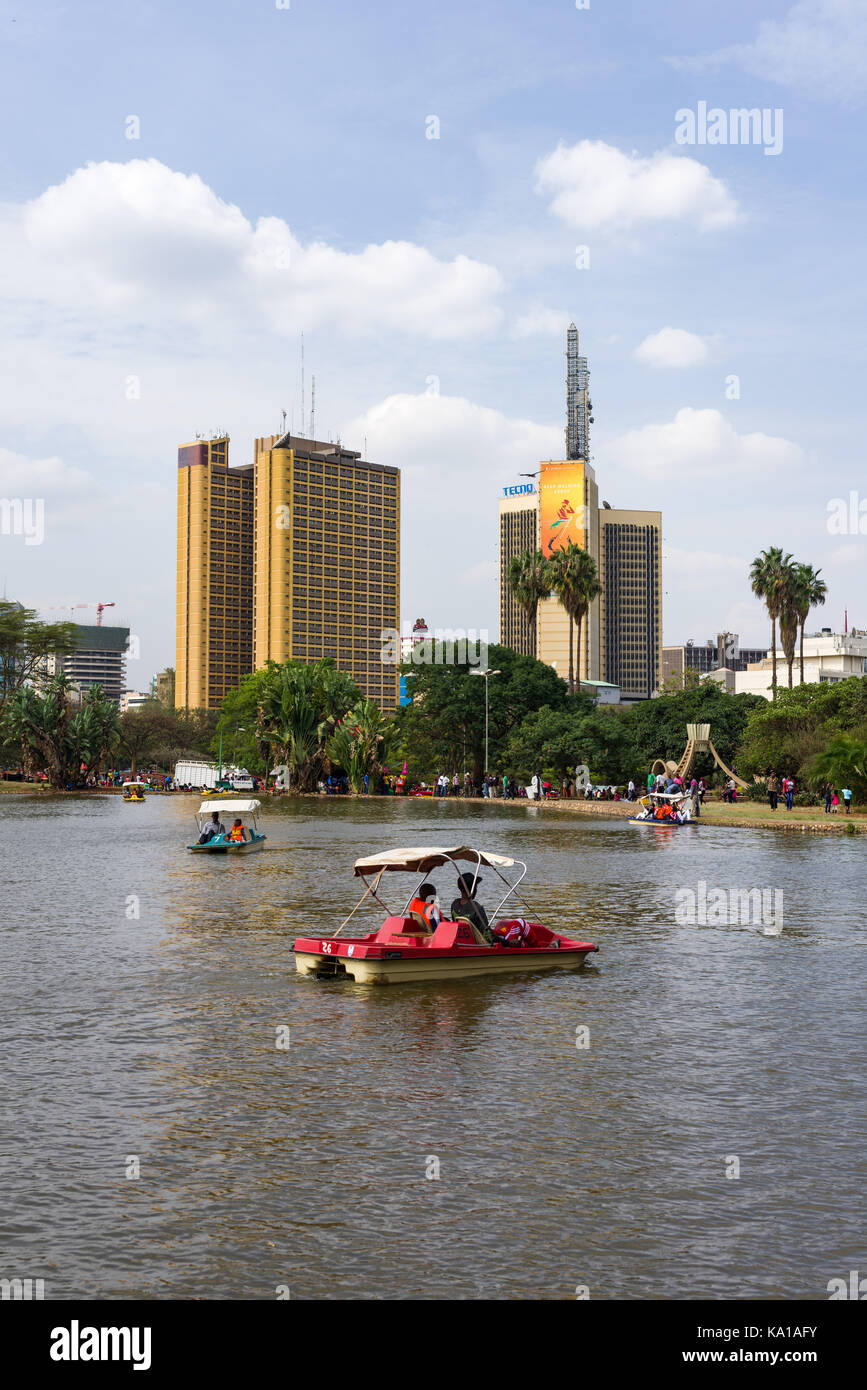 Les personnes bénéficiant de colporter des promenades en bateau ainsi que de s'asseoir près de Lake et à les regarder, Uhuru Park, Nairobi, Kenya, Afrique de l'Est Banque D'Images
