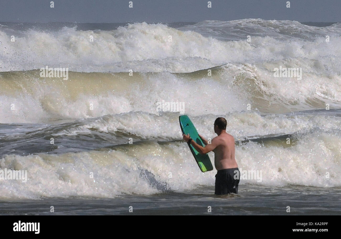Ponce Inlet, united states. 24 sep, 2017. Un homme tente d'entrer dans un mur de vagues avec une petite planche de surf le 24 septembre 2017 à Ponce Inlet, en Floride comme l'ouragan maria charrues jusqu la côte atlantique réunissant de hautes vagues et courants de retour après avoir fait un coup direct à Puerto Rico, en laissant toute l'île sans électricité. crédit : Paul Hennessy/Alamy live news Banque D'Images