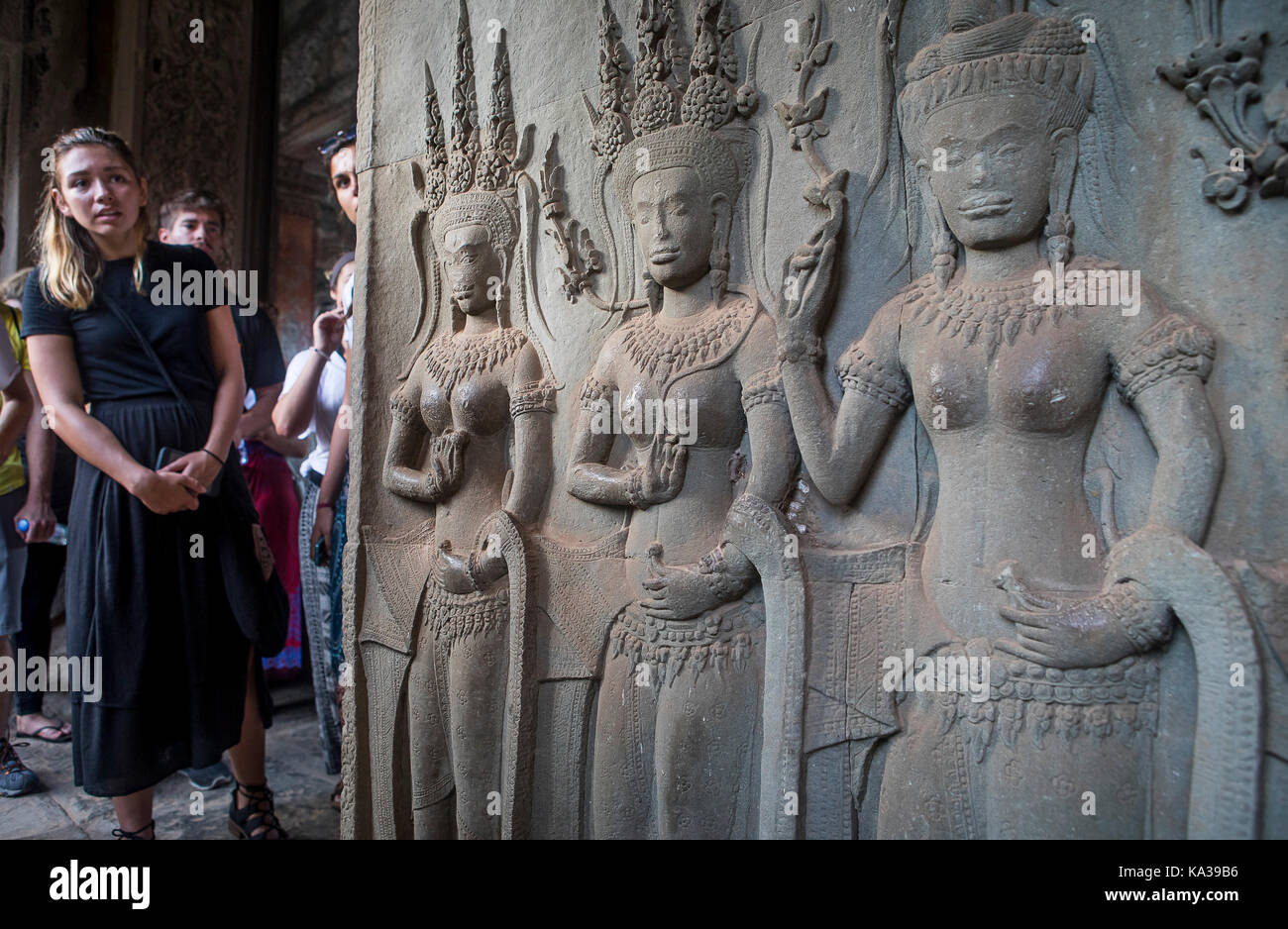 Touristes, et sculptures d'Apsara dans le bas-relief sur le mur, à Angkor Wat, Siem Reap, Cambodge Banque D'Images