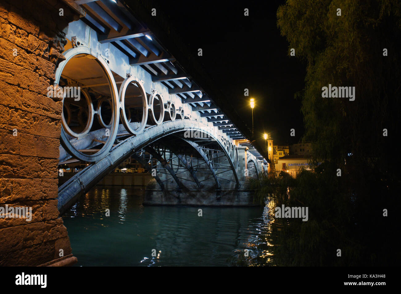 Vue nocturne du pont de Triana (Puente de Isabela II) sur le canal de Alfonso XIII de Guadalquivir à Séville, Espagne Banque D'Images