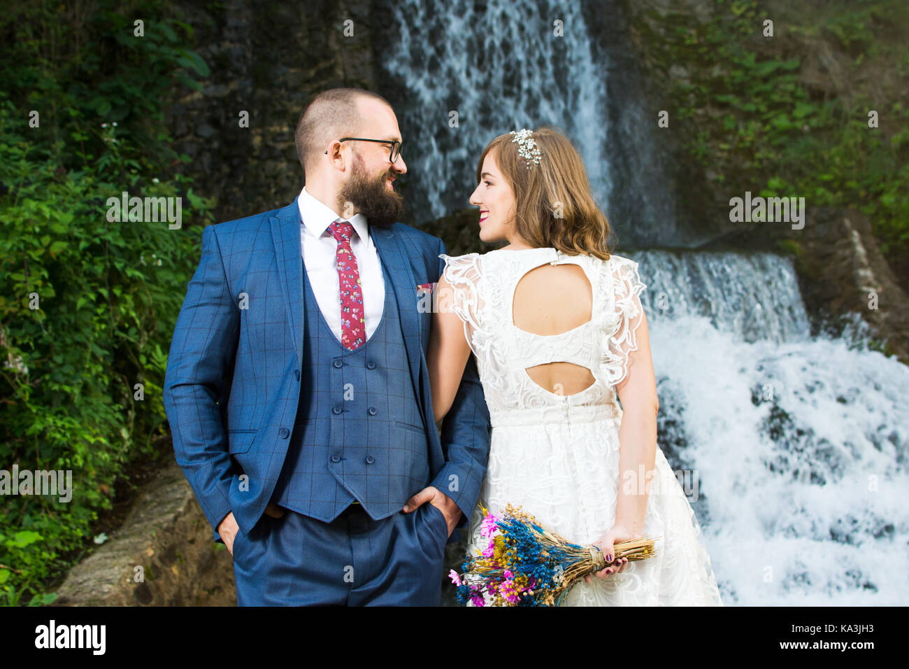 Couple debout devant une cascade Banque D'Images