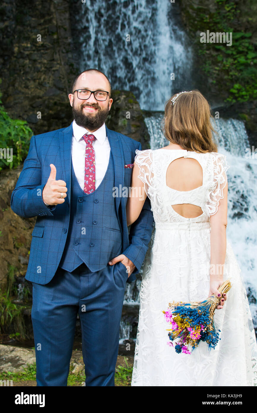 Couple debout devant une cascade Banque D'Images