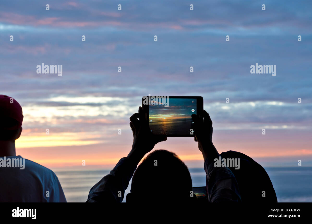 Les personnes qui prennent des photos de la magnifique coucher de soleil avec une tablette mobile sur un traversier de la Colombie-Britannique. BC Ferries voyage à travers les îles du Golfe. Banque D'Images