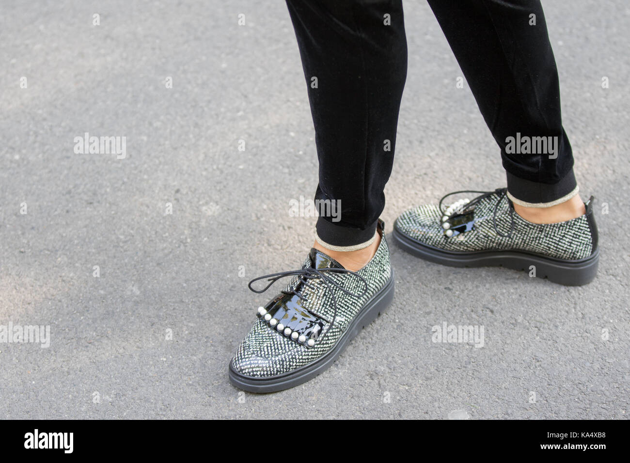 Milan, Italie - 22 septembre 2017 : modèle portant une paire de chaussures blanches et les cases noires avec lacets et pendant le défilé armani, photographier Banque D'Images
