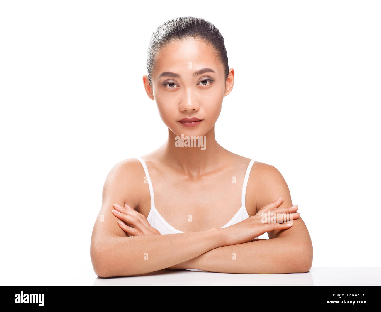 Beau modèle asiatique avec la peau bronzée parfaite et beauté visage. jeune femme à la caméra. studio portrait isolé sur fond blanc Banque D'Images