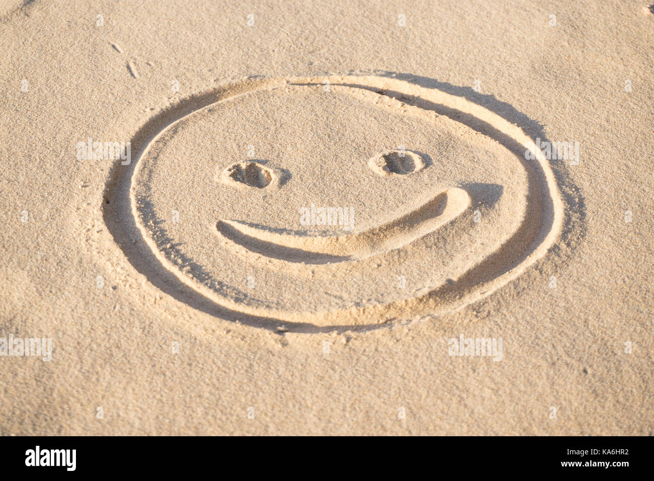Imprime de sourire emoji dans le sable sur la plage de la mer Baltique en été : l'été est presque disparu, en attente de l'automne. Banque D'Images