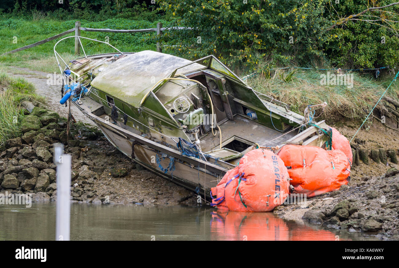 Petit bateau épave abandonnée sur le bord d'une rivière. Banque D'Images