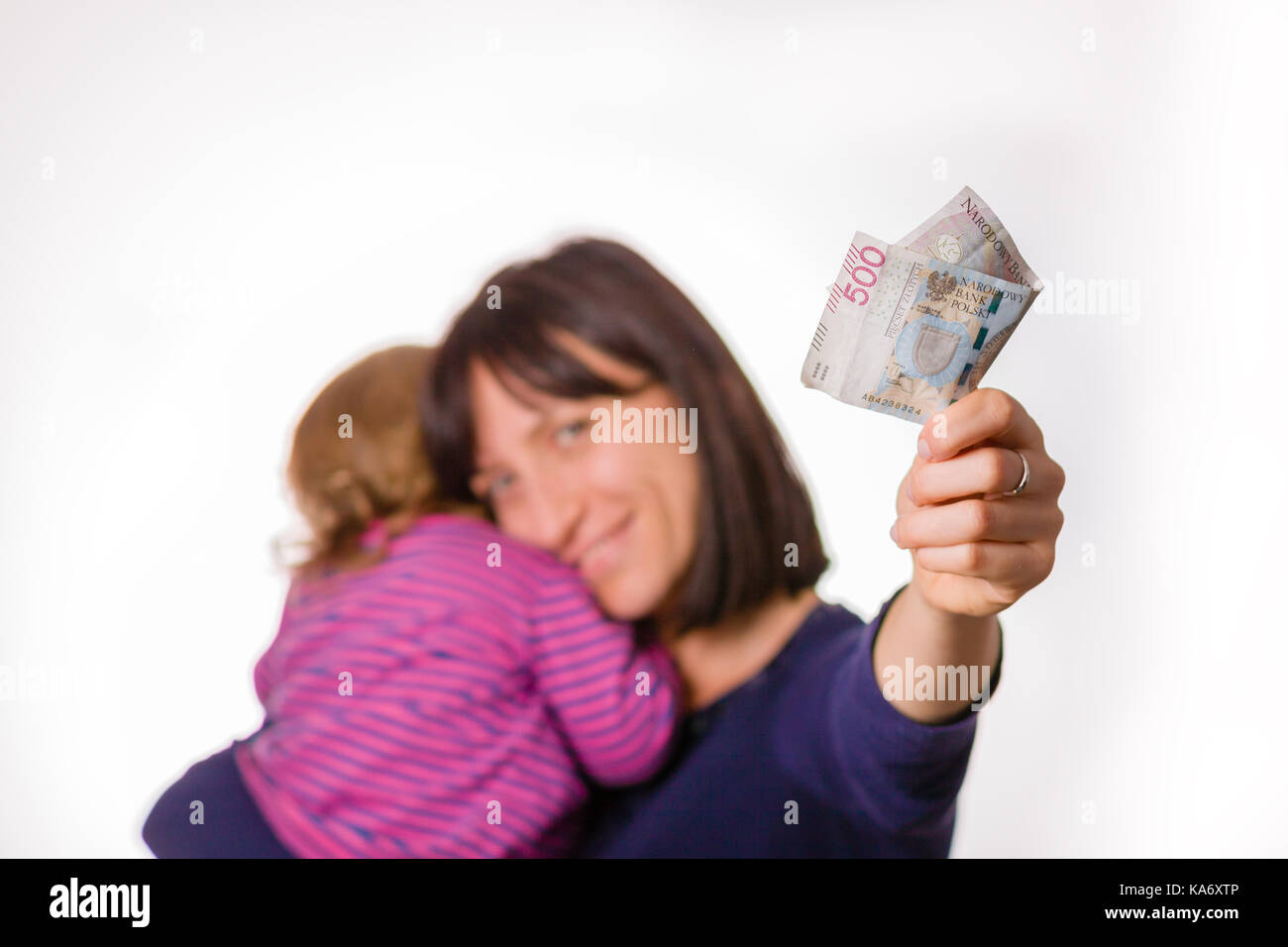 Mère avec petite fille tient en main 500 zlotys. symbole de 500 billets  + programme polonais pour les familles. Banque D'Images