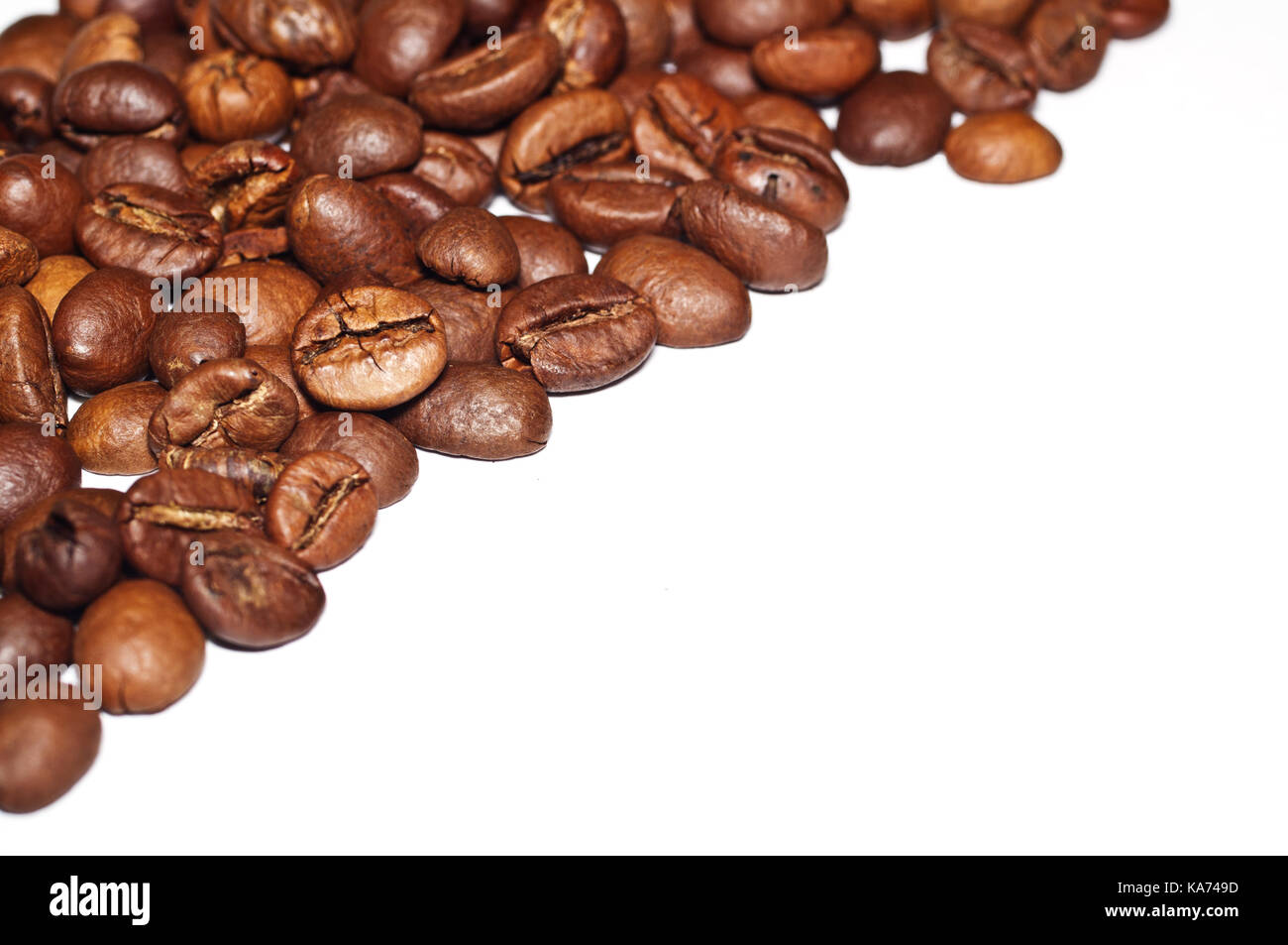 Les grains de café frits sur un fond blanc. Banque D'Images