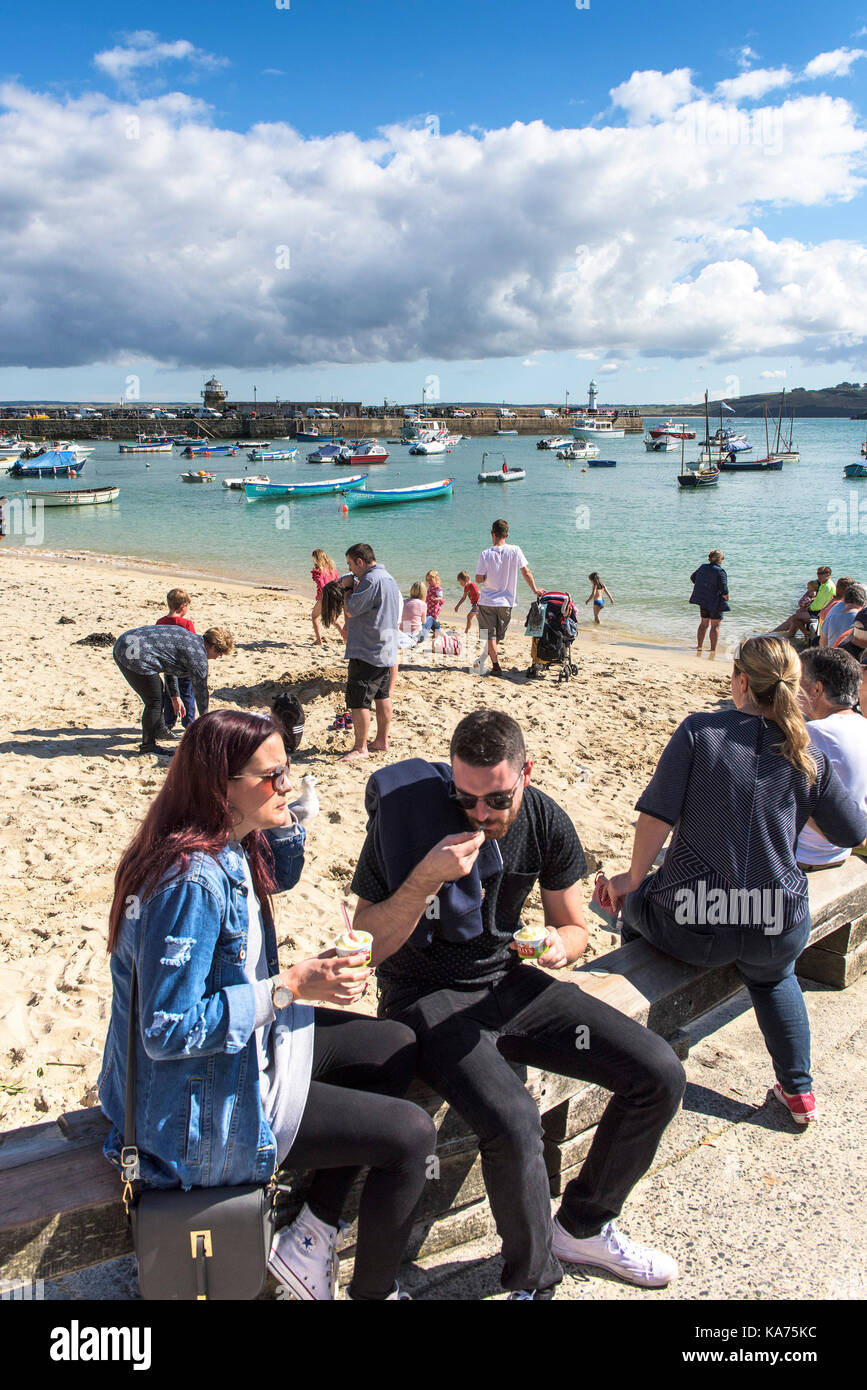St Ives - vacanciers détente sur la plage du port de St Ives en Cornouailles. Banque D'Images