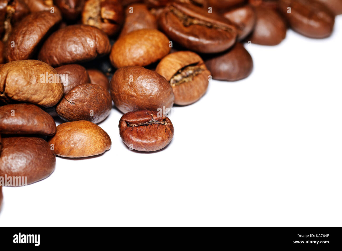 Les grains de café frits sur un fond blanc. Banque D'Images