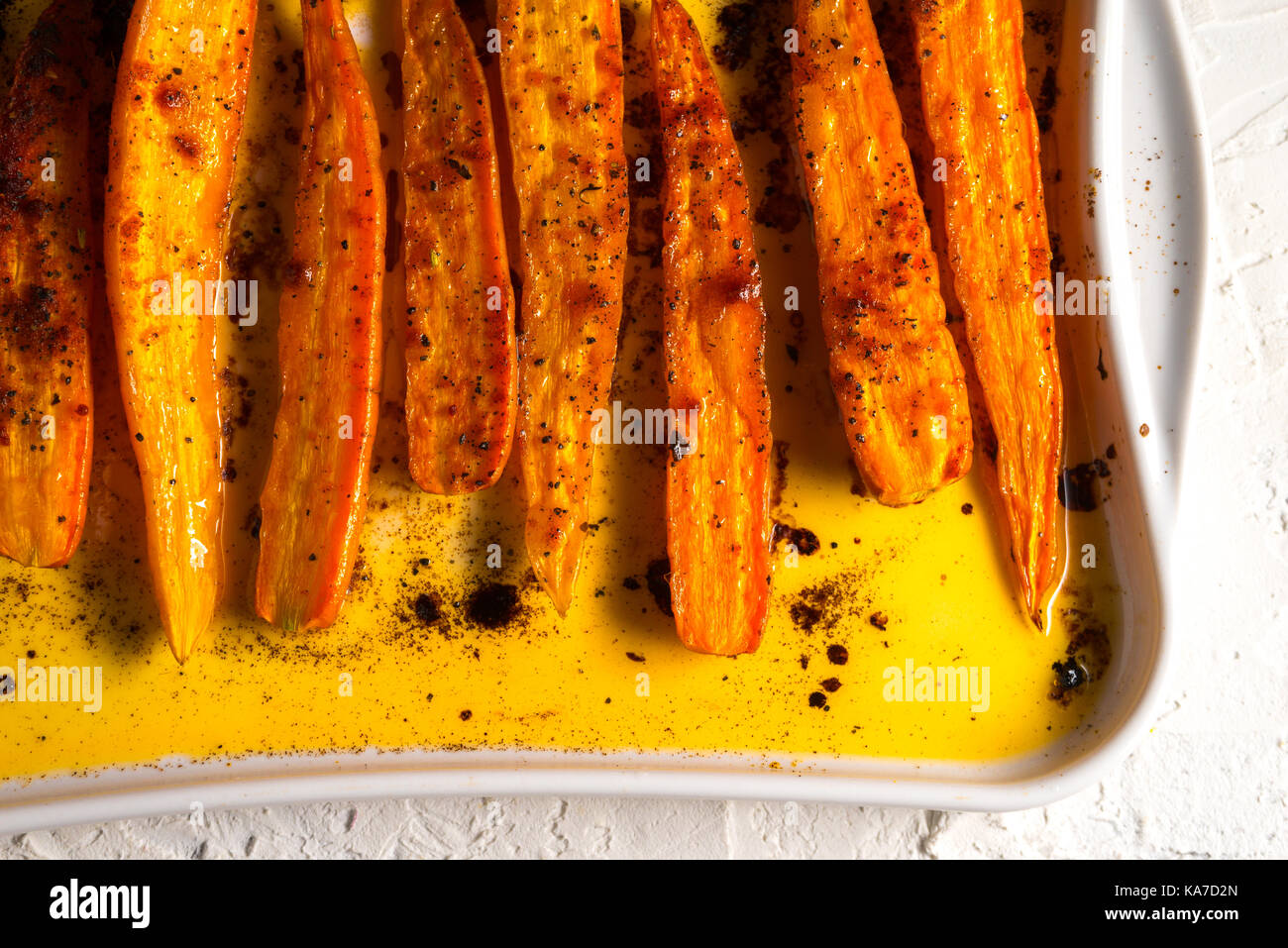 Compotée de carottes orange dans les épices sur une plaque de cuisson l'horizontale Banque D'Images