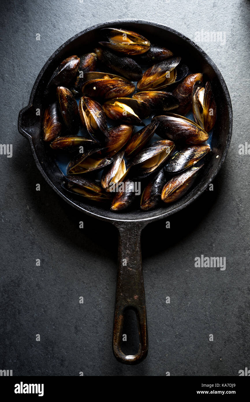 Les moules cuites sur un poêle en fonte à la verticale Banque D'Images