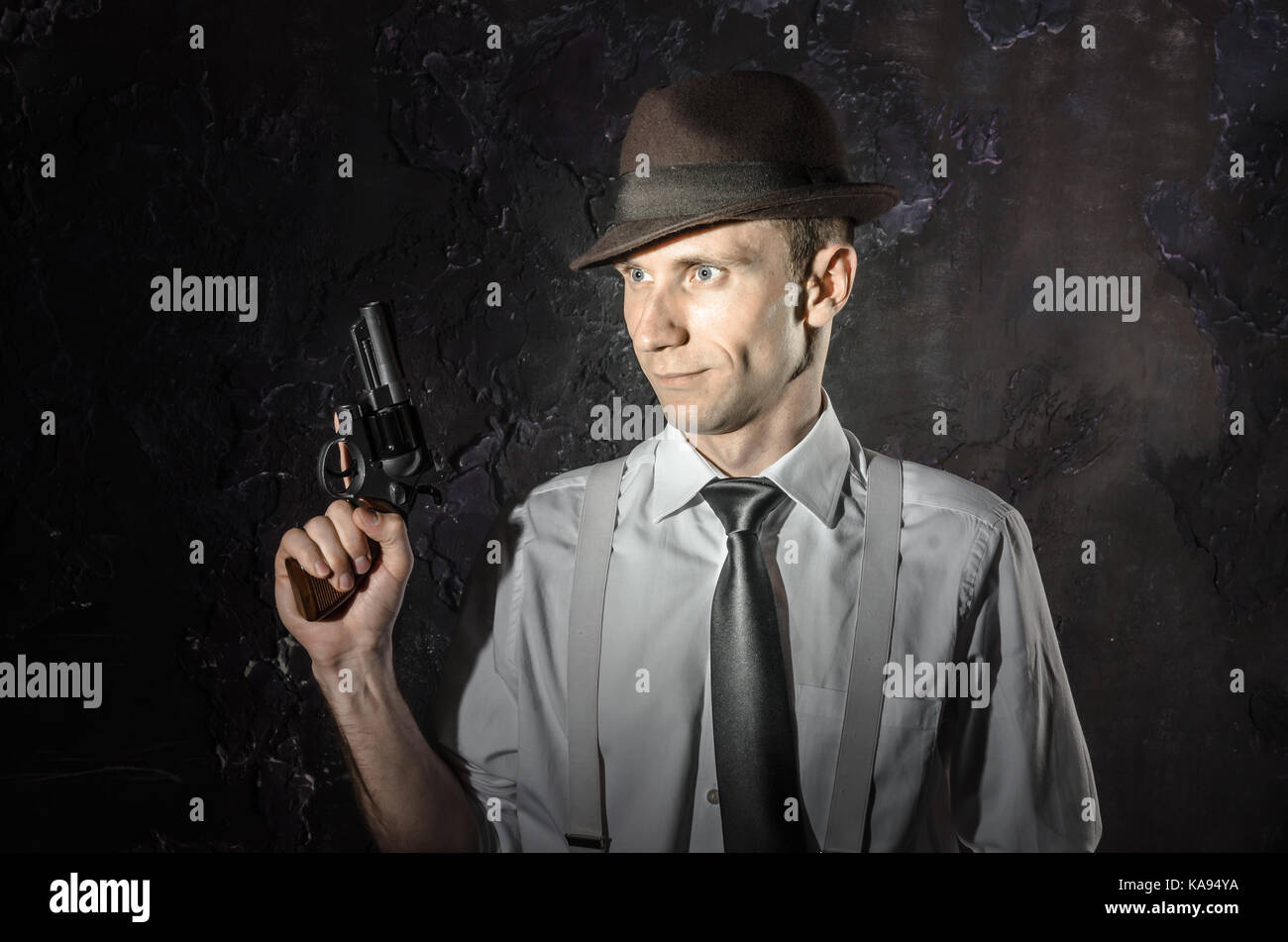 Photo noir et blanc d'un détective privé avec une arme à deux mains. Dans l'élégant Agent hat. L'homme reste l'avant à l'appareil photo. Il porte la chemise classique avec Banque D'Images Photo noir et blanc d'un détective privé avec une arme à deux mains. Dans l'élégant Agent hat. L'homme reste l'avant à l'appareil photo. Il porte la chemise classique avec Banque D'Images