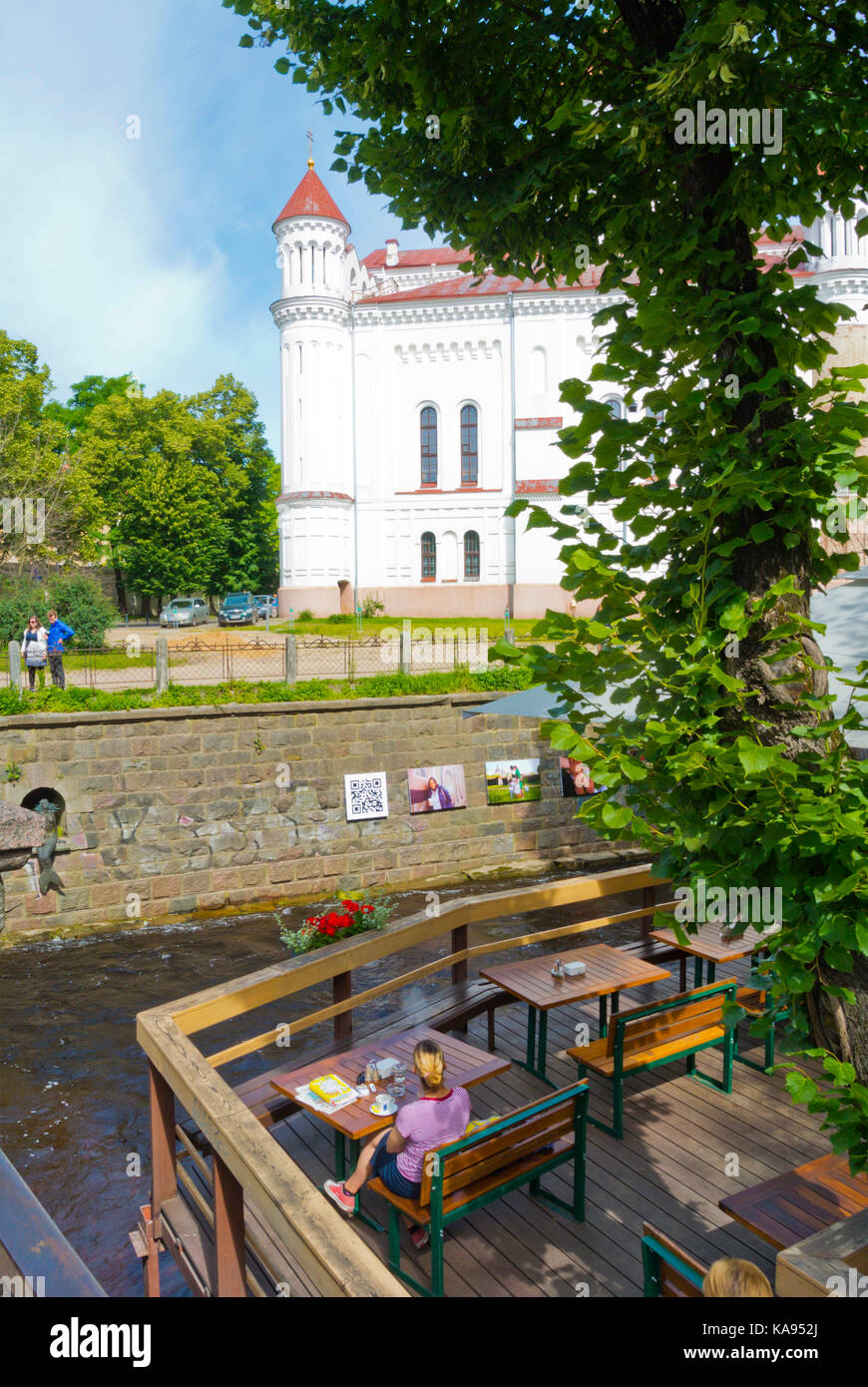 Terrasse de café par la rivière Vilnia, avec en arrière-plan, la cathédrale orthodoxe Uzupis, Vilnius, Lituanie Banque D'Images