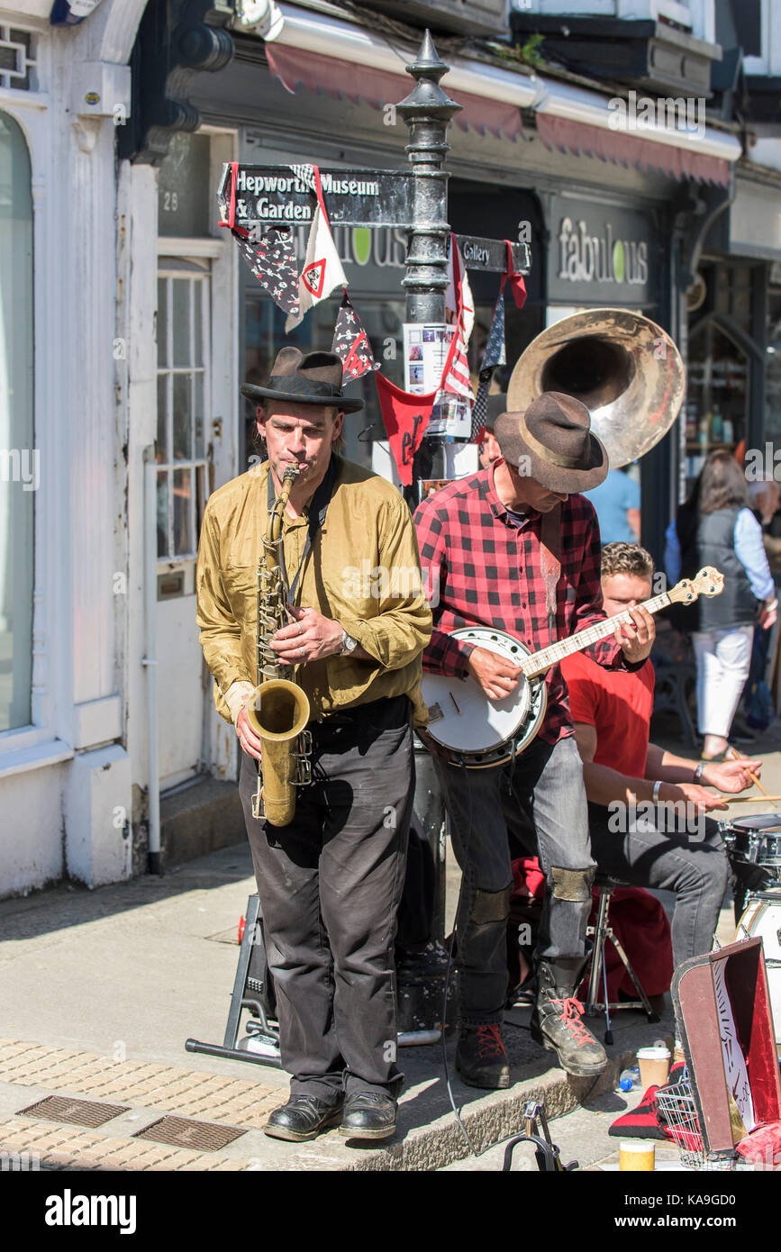 Artistes de rue - la rue du spectacle ou des amuseurs de swervy monde jouant dans le centre de St Ives en Cornouailles. Banque D'Images