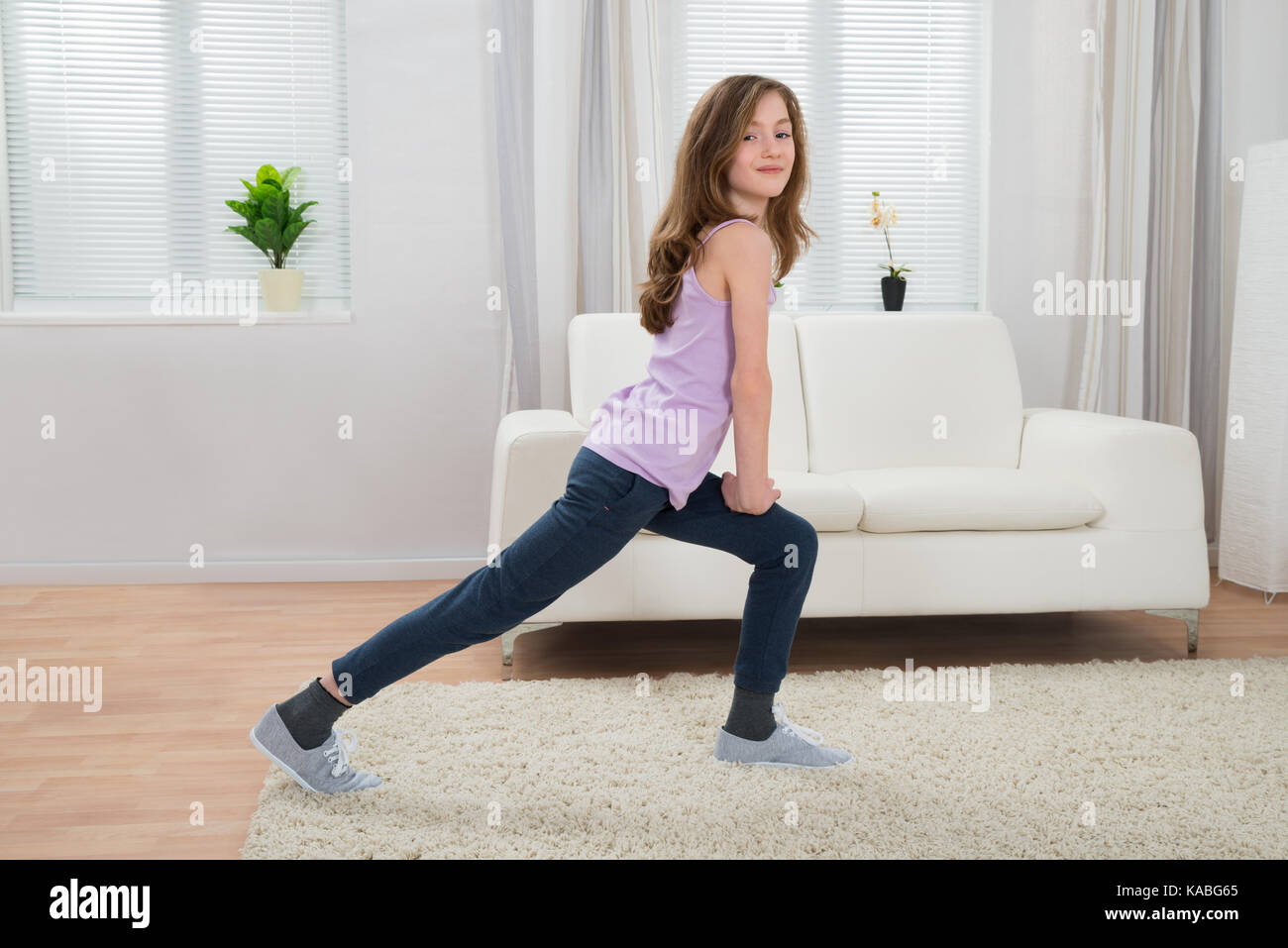 Fille dans l'exercice de sport dans la salle de séjour Banque D'Images