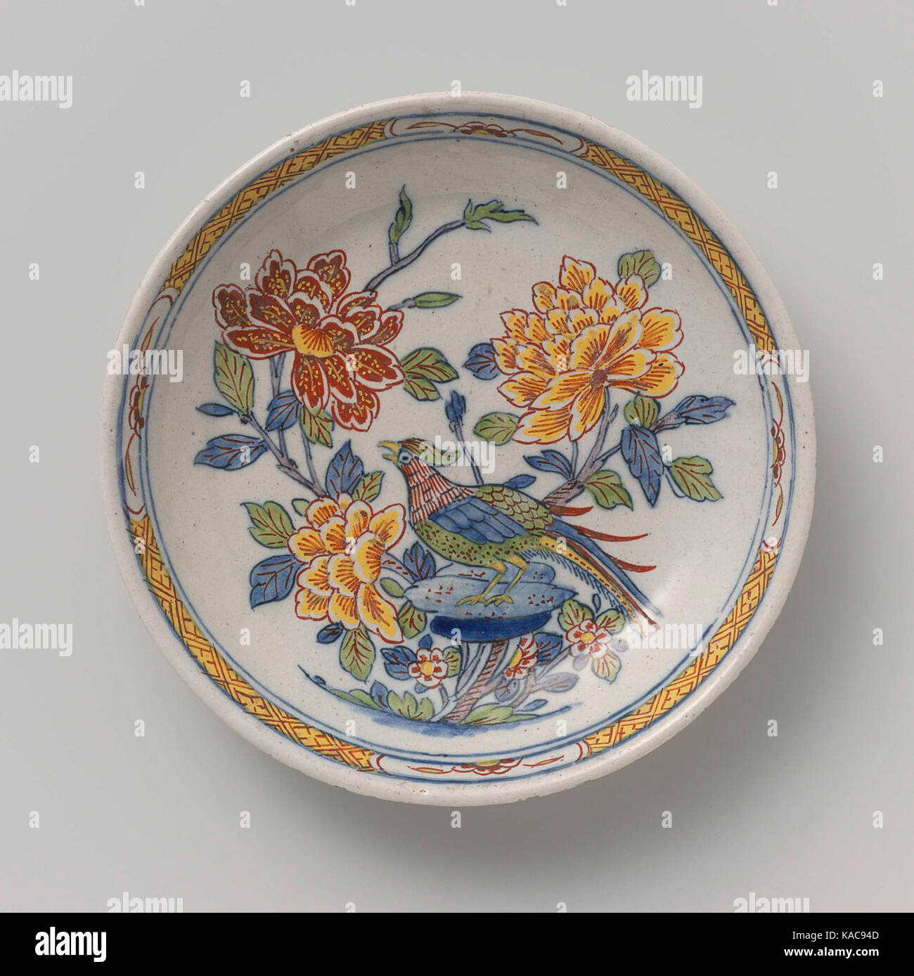 La plaque est peinte avec des branches florales et un oiseau, affichant un art hollandais complexe, typique du XVIIe ou XVIIIe siècle, mettant en valeur l'artisanat détaillé de la porcelaine décorative. Banque D'Images