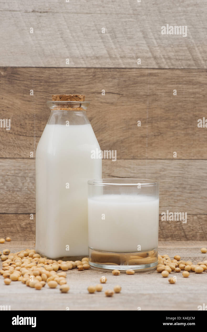 Bouteille de lait de soja et de soja sur table en bois Banque D'Images