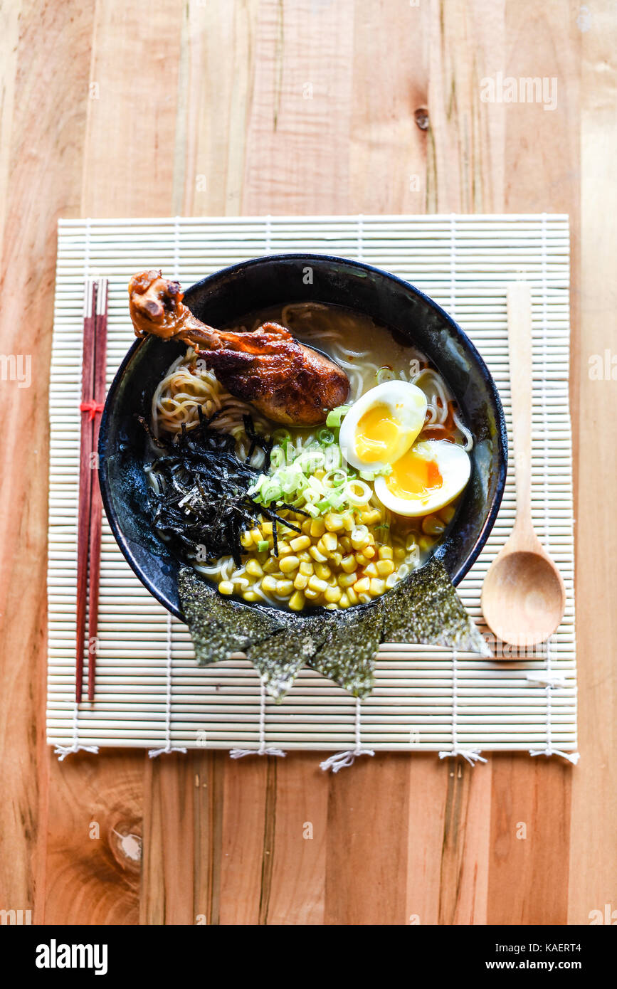 Le miso ramen goût poulet, emballé avec une pâte miso mélangé. garnie de maïs beurré et pilons de poulet. Banque D'Images