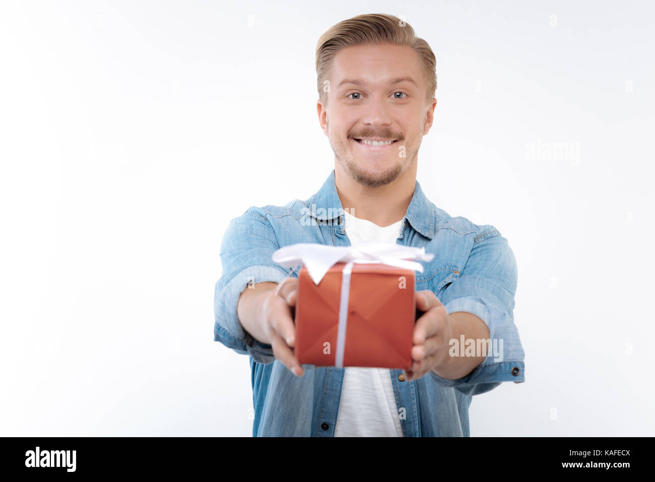 Jeune homme optimiste de remettre une boîte-cadeau Photo Stock - Alamy