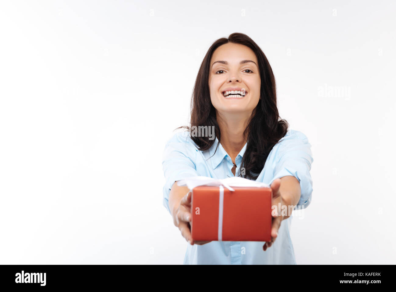 Jeune femme heureuse de remettre une boîte cadeau rouge Banque D'Images