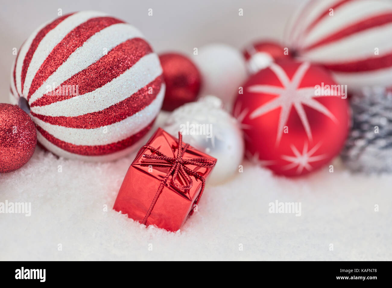 Présent rouge comme fond de Noël avec de nombreux baubles Banque D'Images Présent rouge comme fond de Noël avec de nombreux baubles Banque D'Images