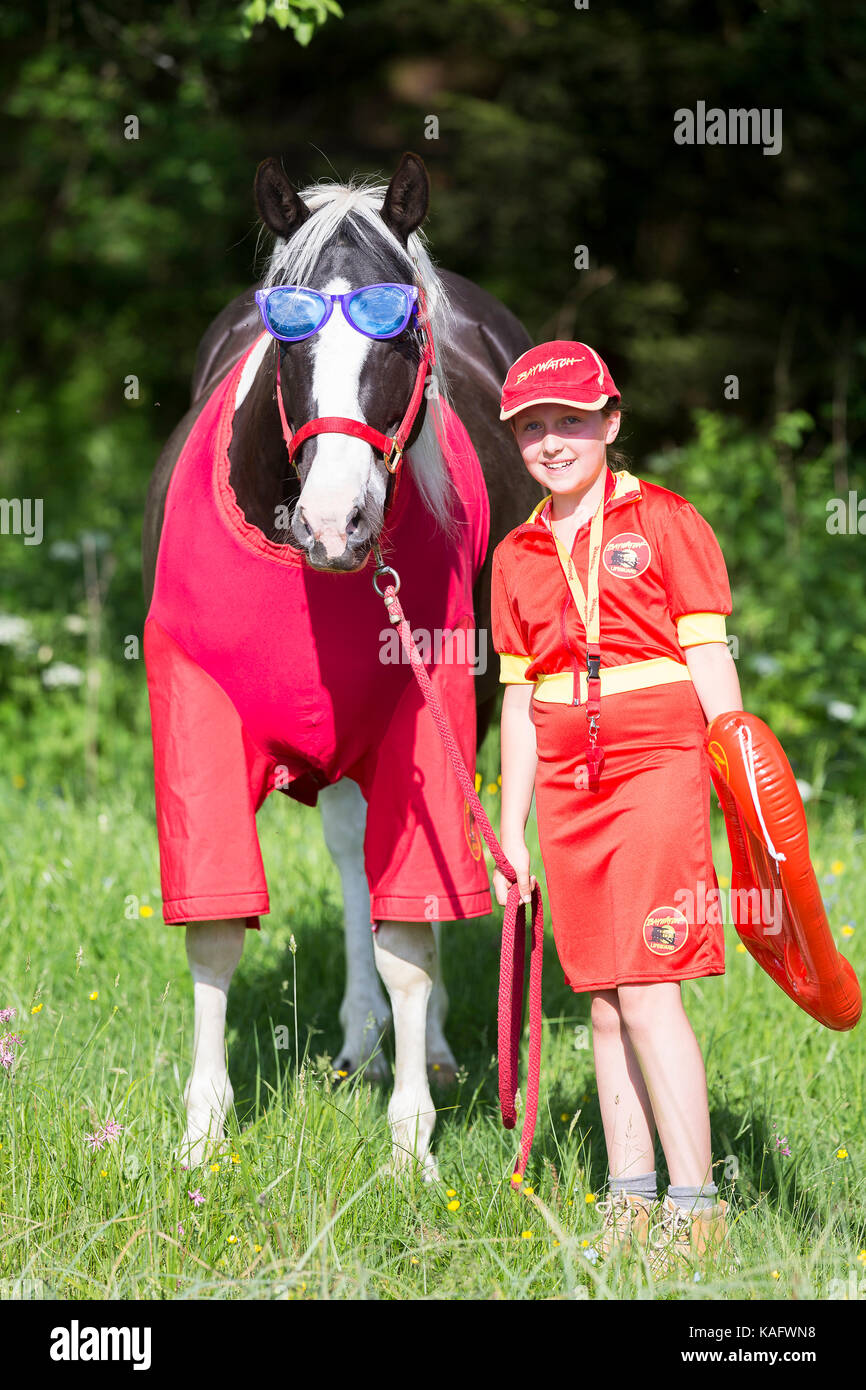 American Paint horse. Enfant et cheval en costumes de sauveteur (baywatch). L'Autriche Banque D'Images