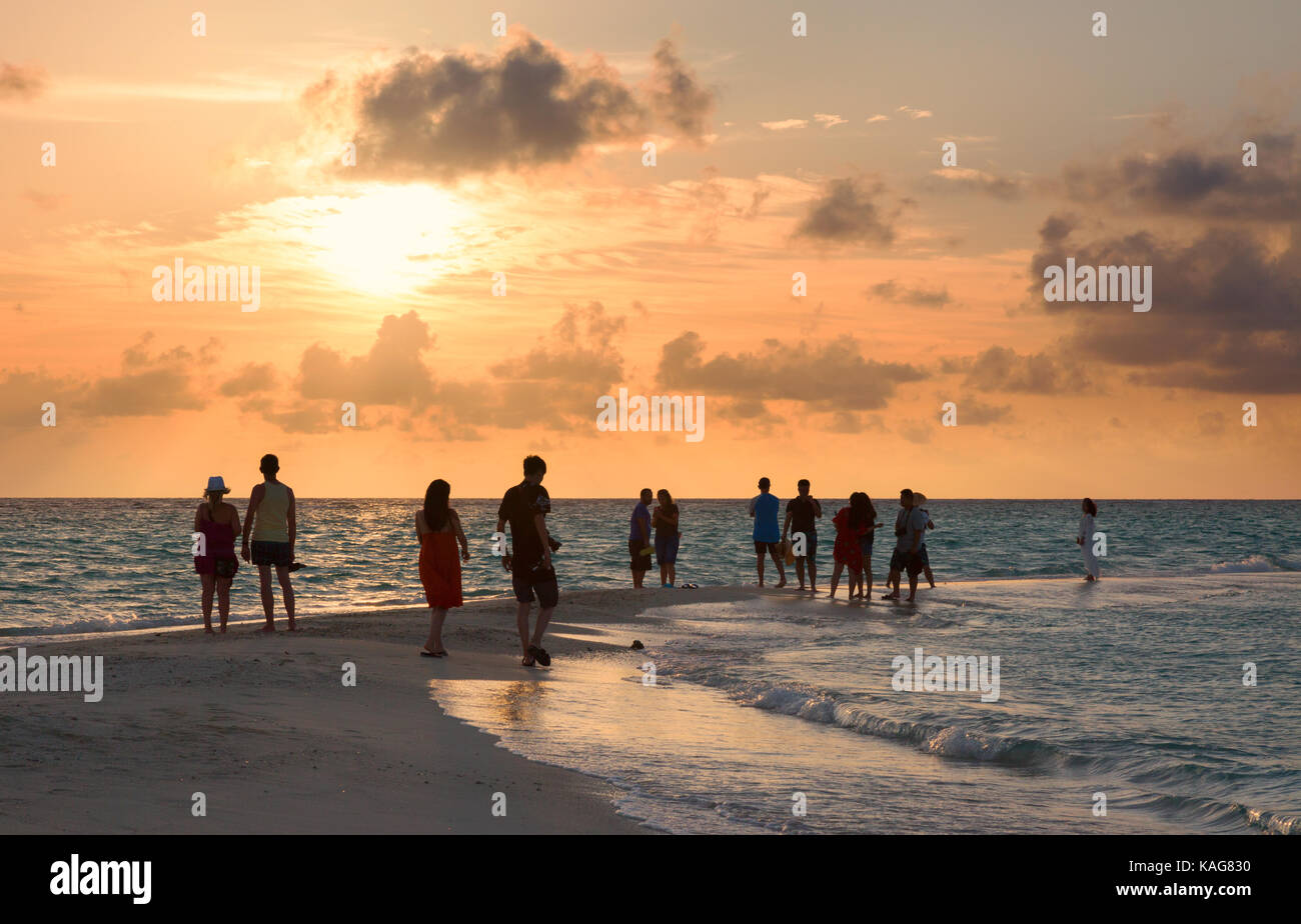 Maldives coucher du soleil - les gens à regarder le coucher du soleil sur l'Océan Indien à partir de la plage, Kuramathi Island resort Maldives, l'Asie Banque D'Images