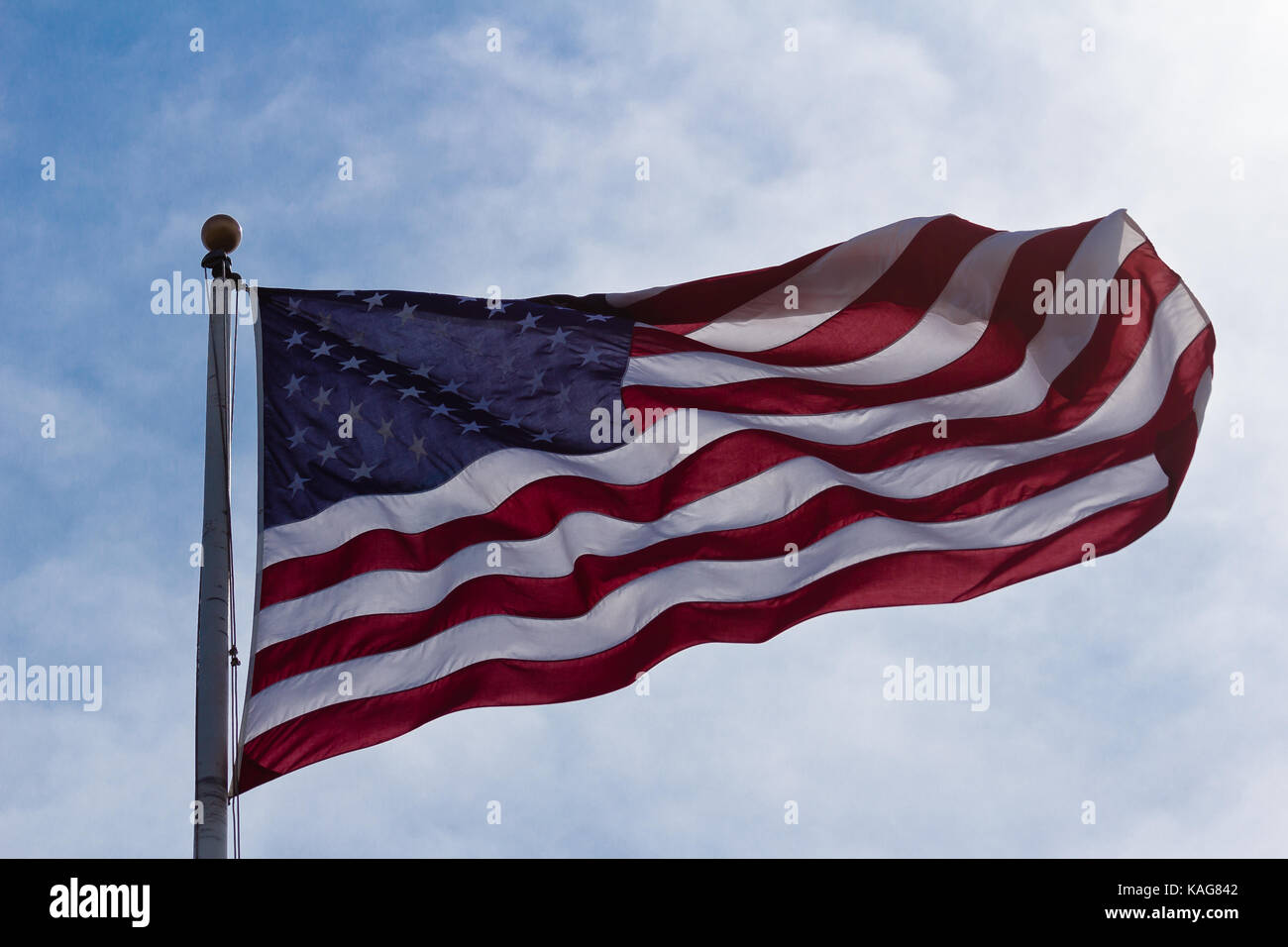 Drapeau américain avec sun shining through sur jour de vent. Banque D'Images