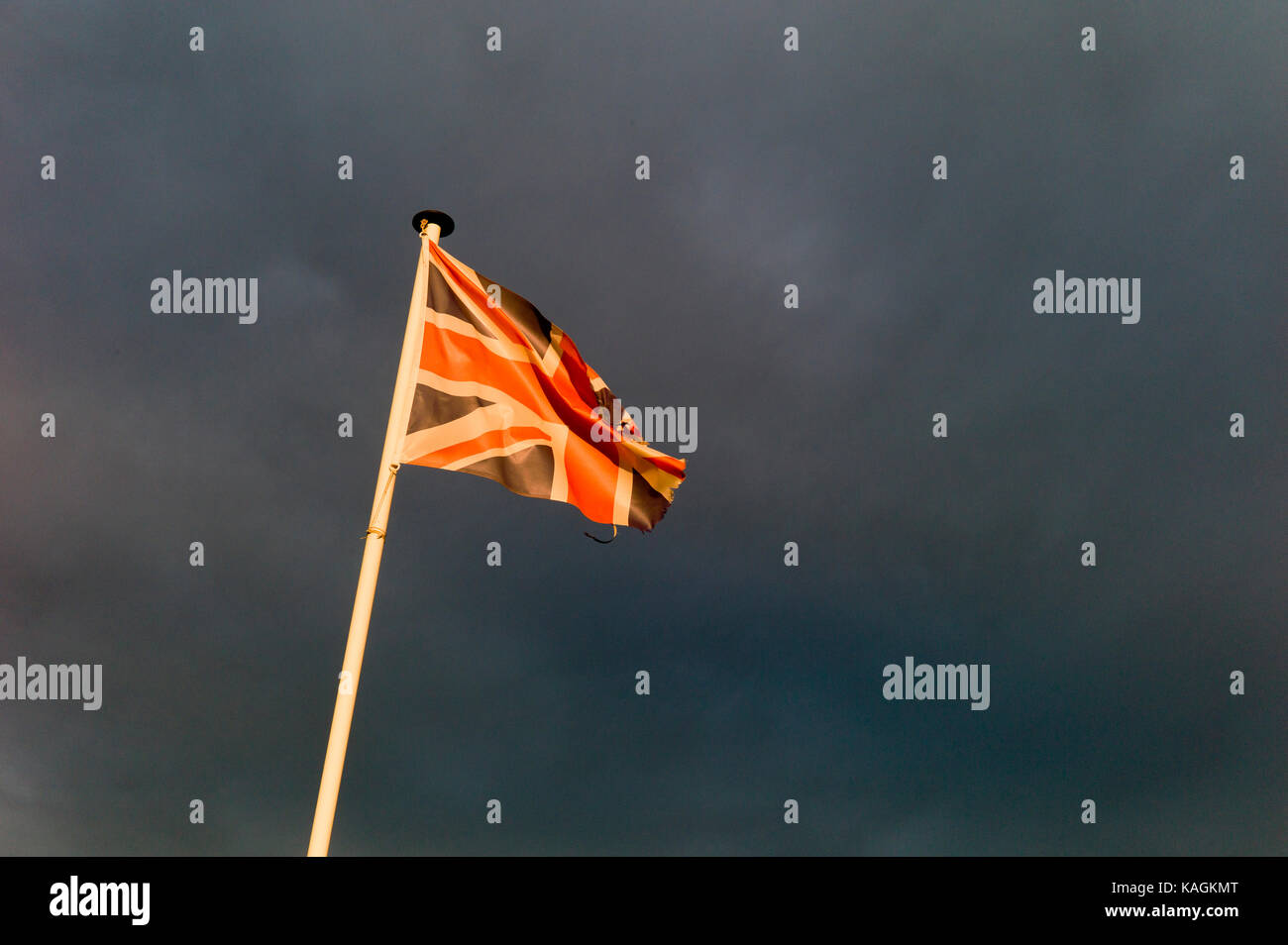 Tattered Union jack volant sous ciel d'orage Banque D'Images