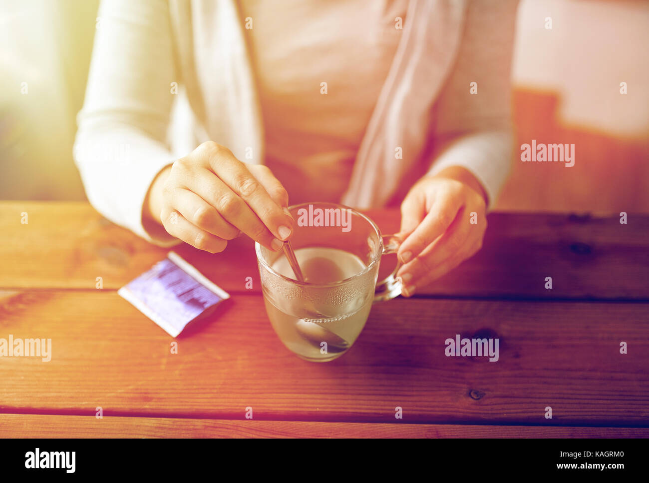 Femme en remuant de médicament en tasse avec cuillère Banque D'Images
