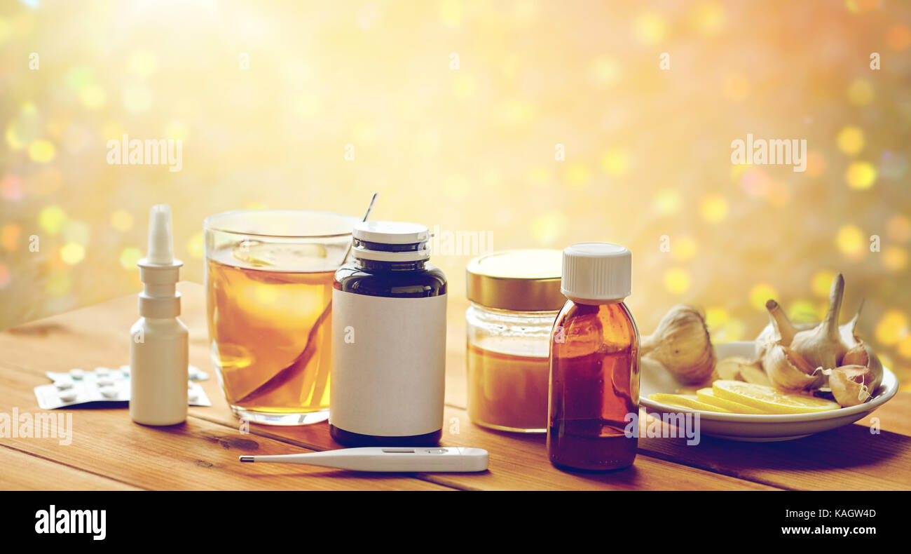 La drogue, thermomètre, le miel et une tasse de thé sur bois Banque D'Images