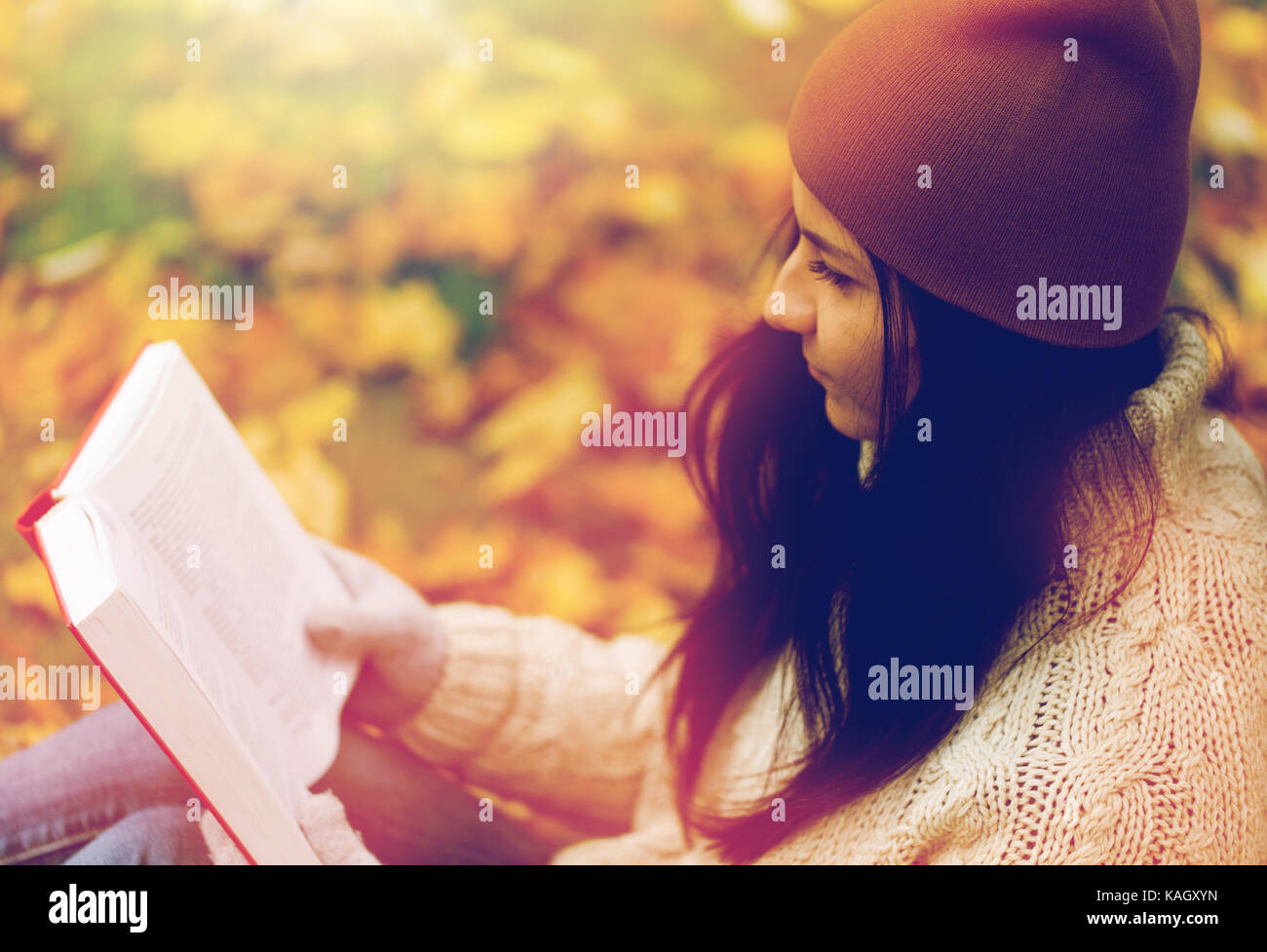 Close up of woman reading book in autumn park Banque D'Images