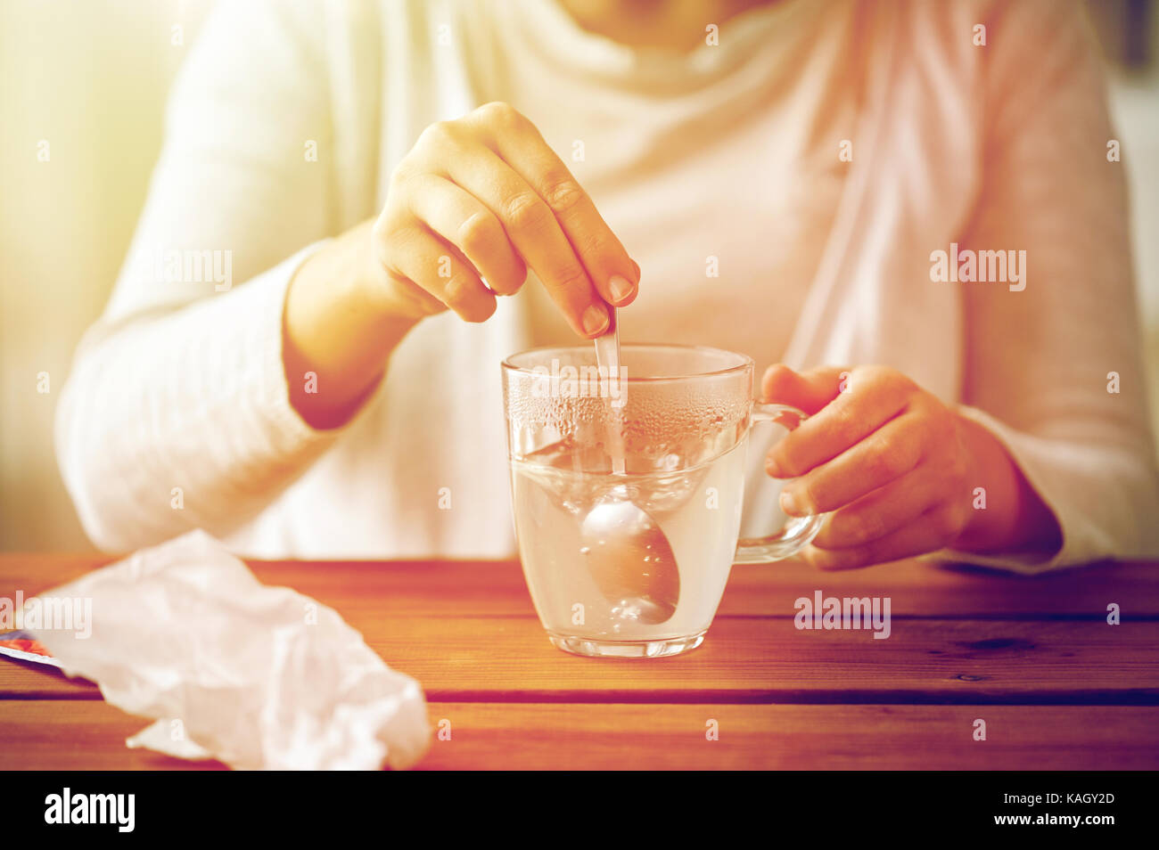 Femme en remuant de médicament en tasse avec cuillère Banque D'Images
