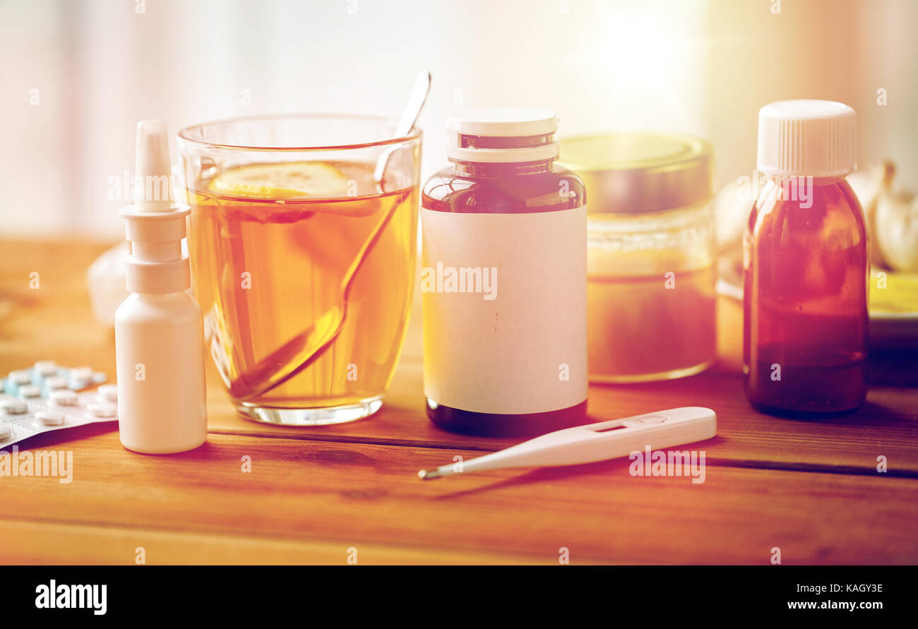 La drogue, thermomètre, le miel et une tasse de thé sur bois Banque D'Images