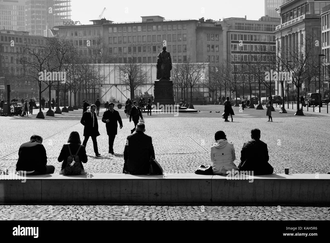 Frankfurt am Main, Allemagne - le 16 mars 2017 : les touristes assis sur le parapet et se dépêchant d'affaires à la place Goetheplatz à goethe monument et buil Banque D'Images
