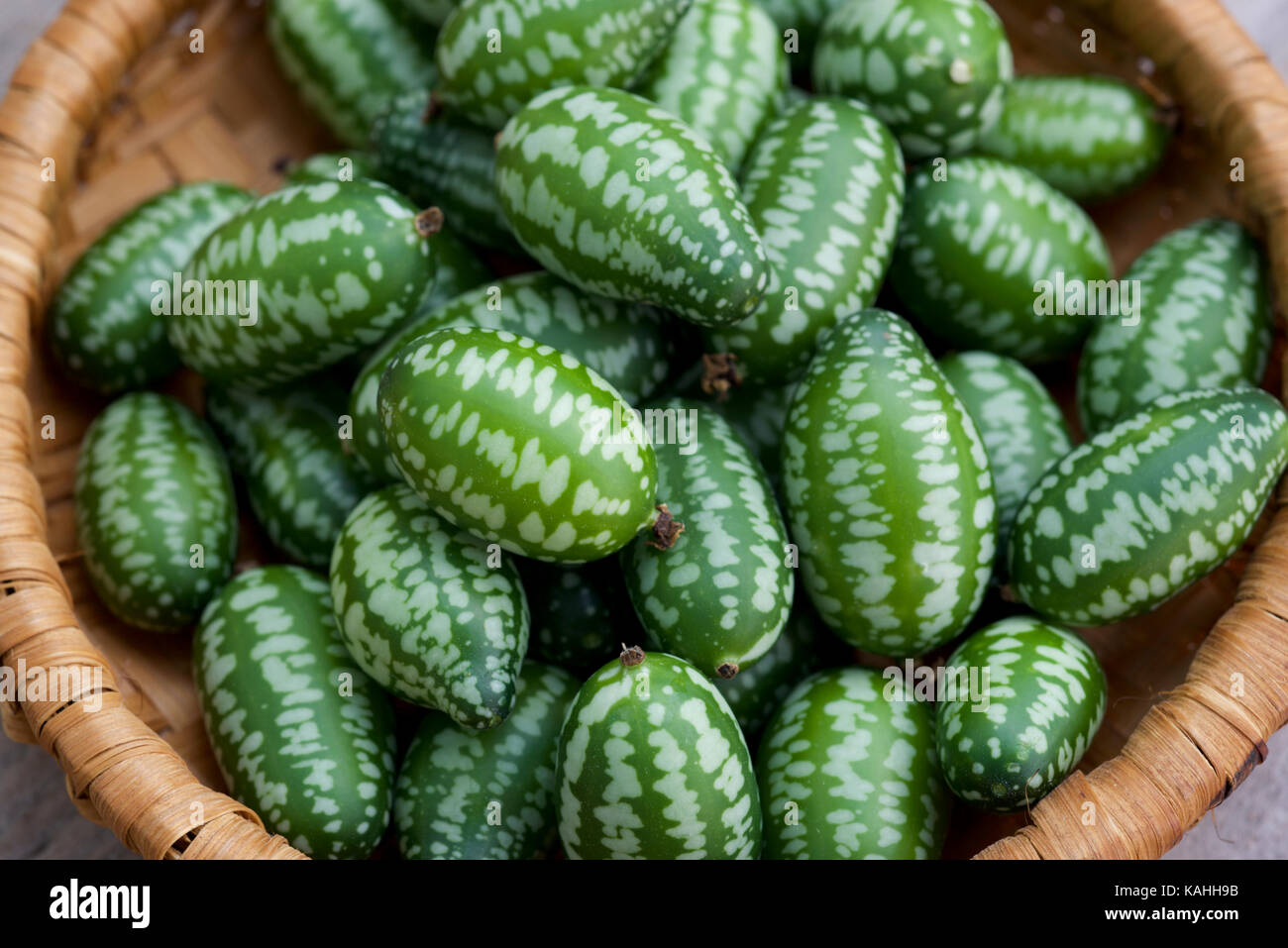 Cucamelon fruits, également connu sous le nom de cornichons aigre mexicain Mexicain, concombres, ou Melothria scabra dans un panier de bambou Vietnamien Banque D'Images