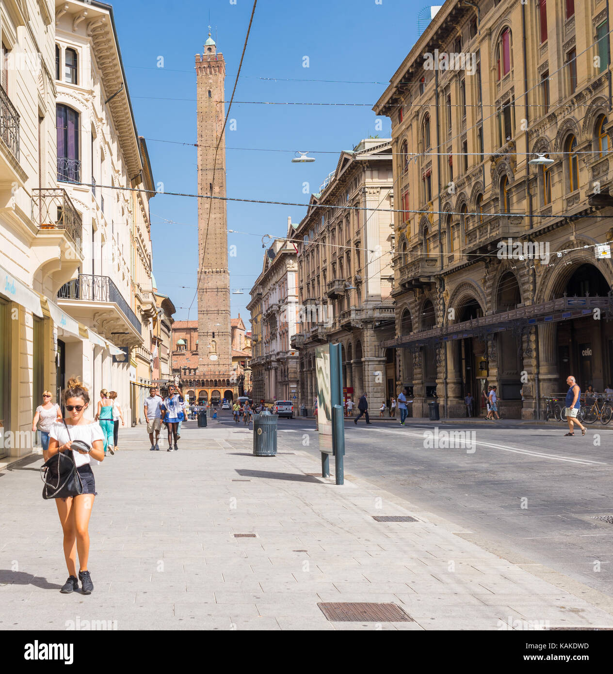 Les gens qui marchent dans la "via rizzoli' l'une des rue principale dans le centre historique de Bologne ville avec vue sur la tour asinelli regio emilia-romagna. Banque D'Images