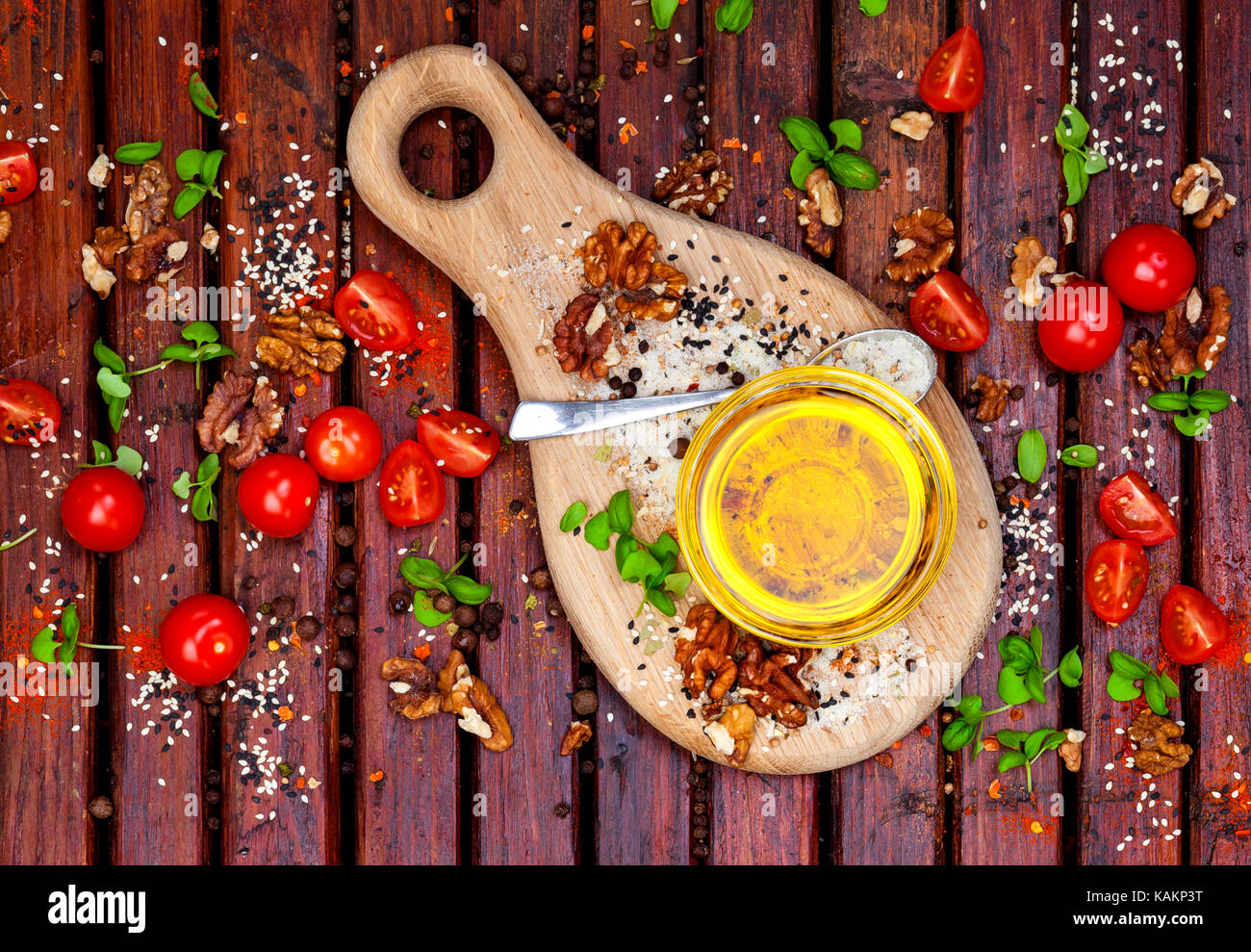 Les épices, les tomates cerises, le basilic et l'huile végétale sur la table en bois sombre, vue du dessus Banque D'Images