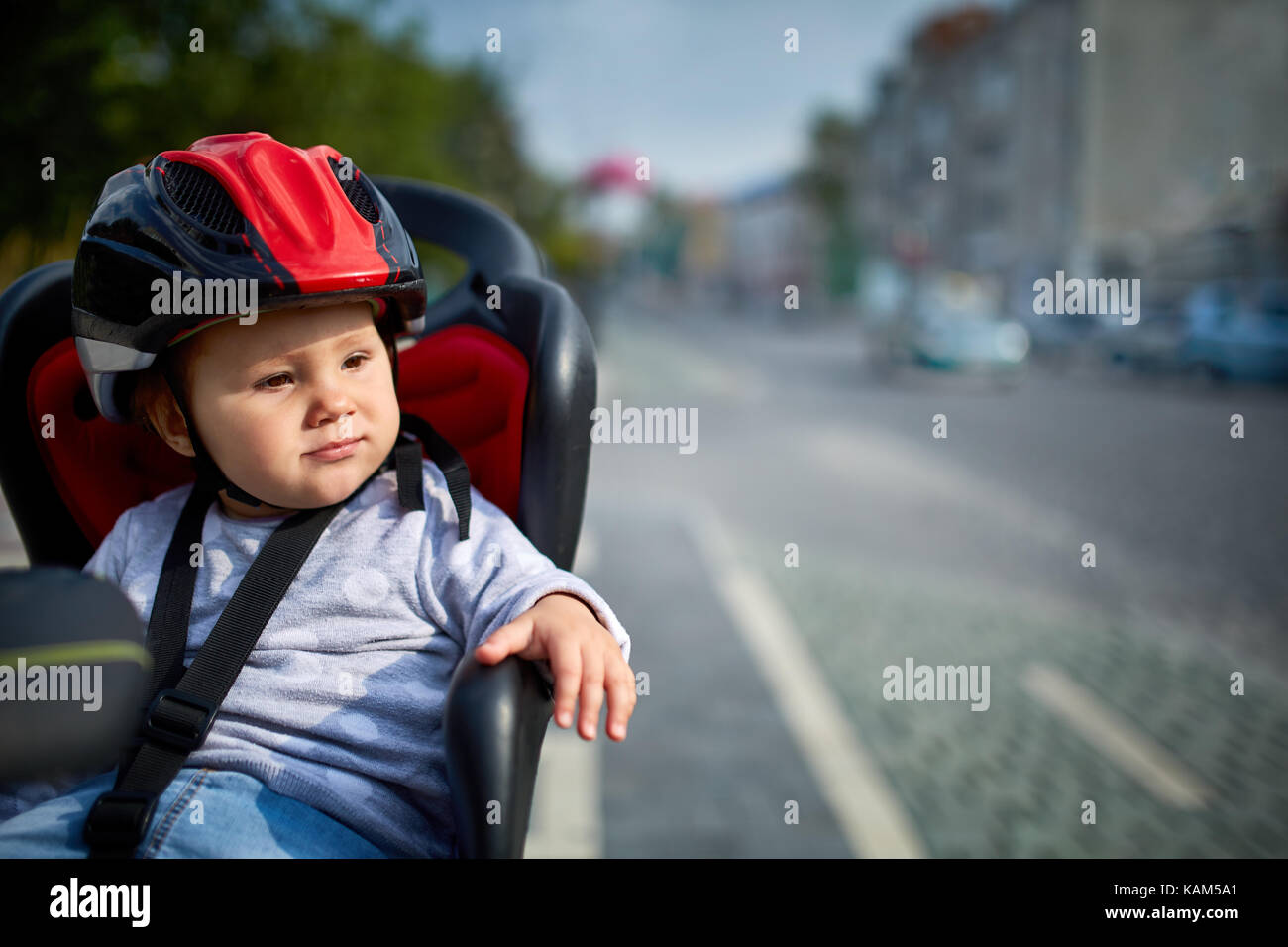 Vélo en famille dans la ville. peu de belle fille portant des casques de vélo. Banque D'Images