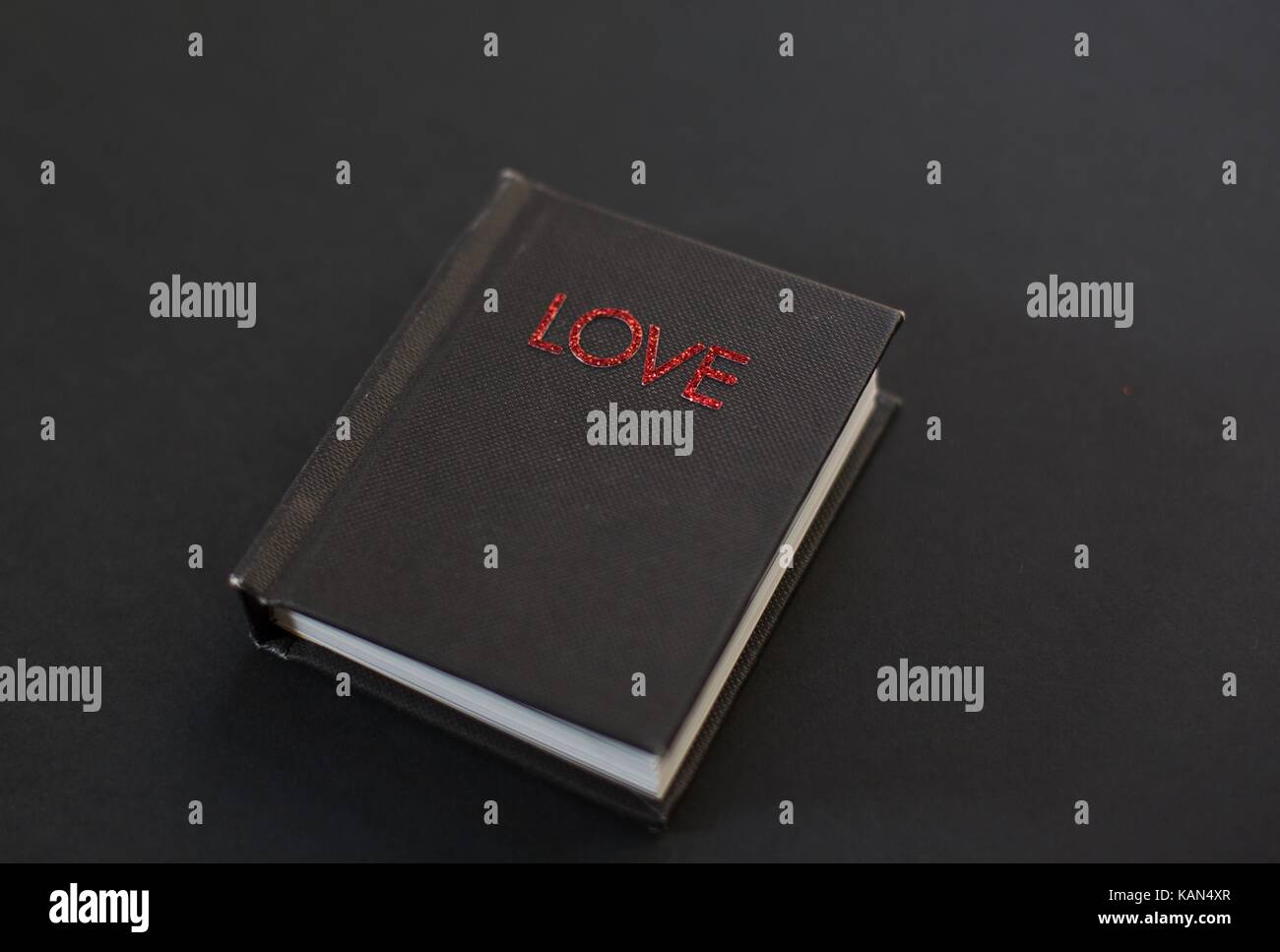 Un petit livre noir intitulé 'love'. Banque D'Images