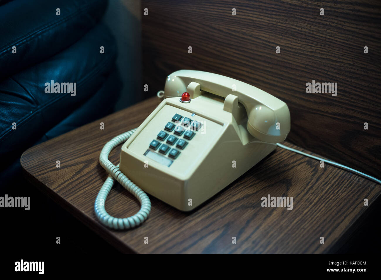 Un vieux téléphone à se trouve à côté d'un lit dans un motel. Banque D'Images