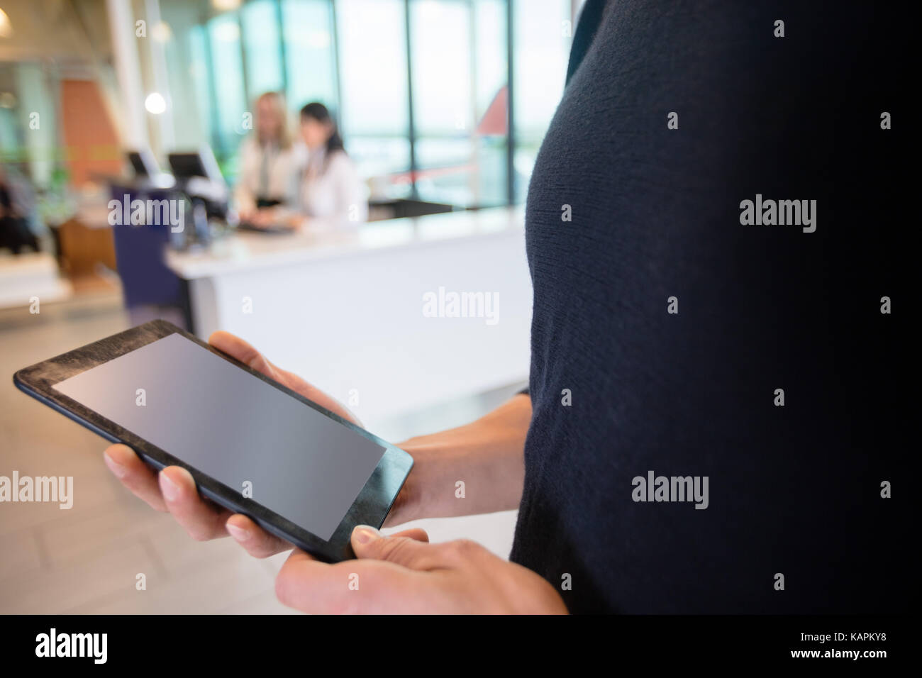 Au milieu du passager using digital tablet at airport Banque D'Images